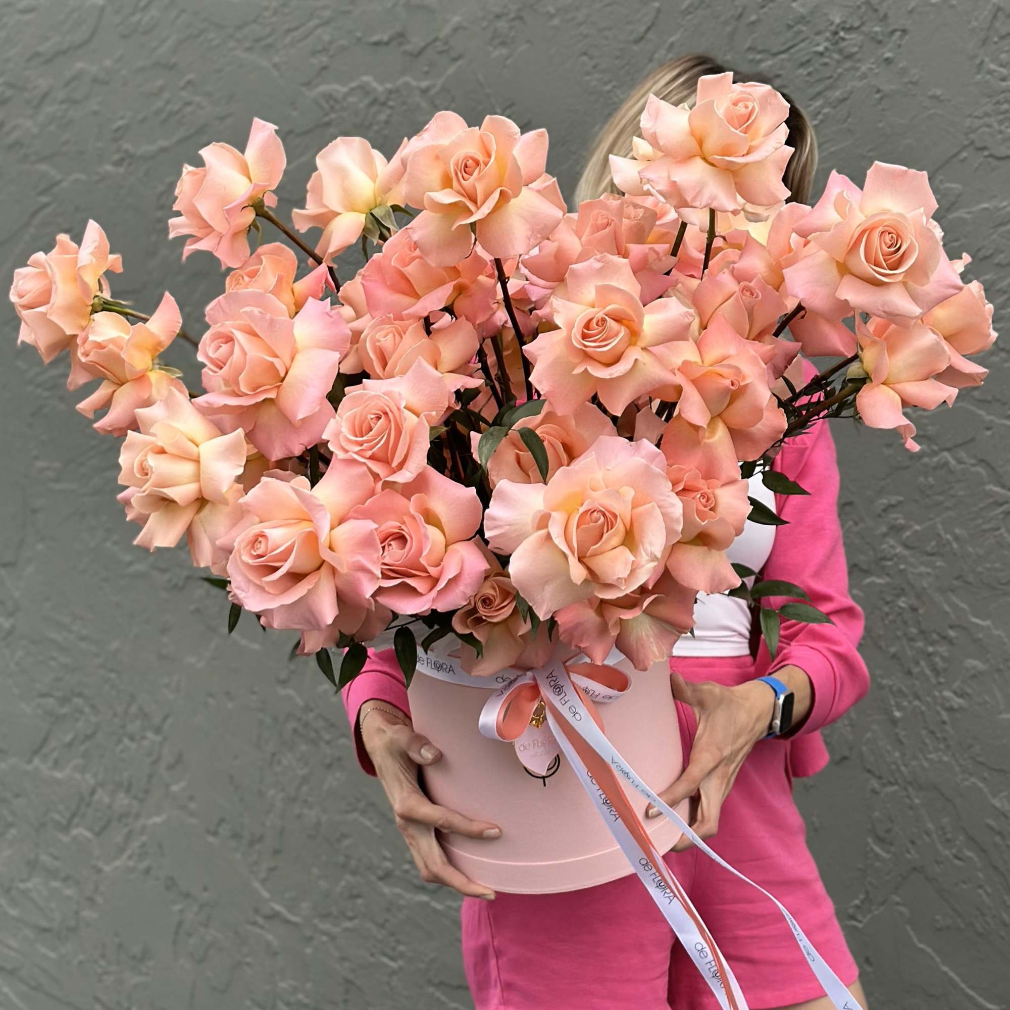 Large bouquet of peach-pink roses in a pink hat box