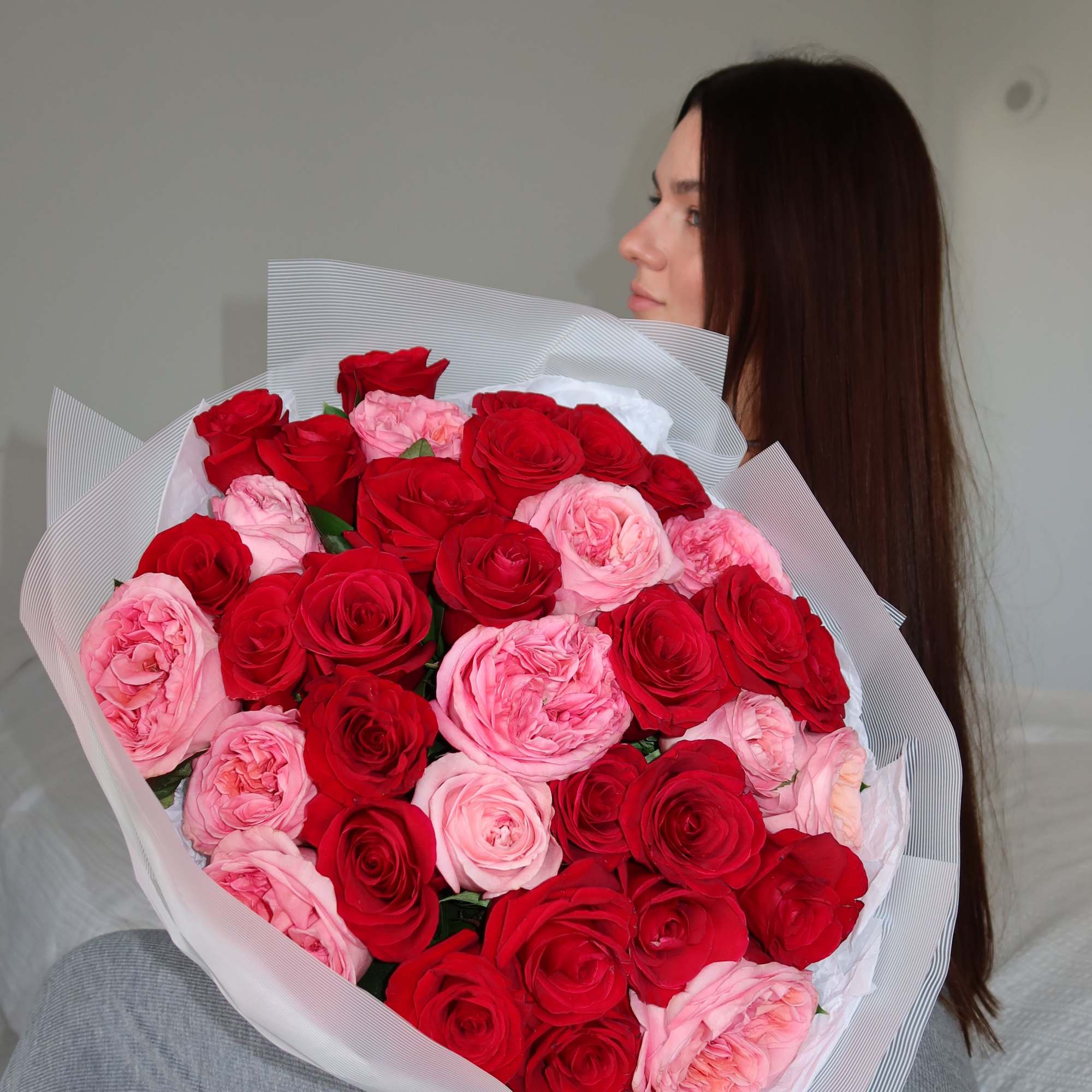 Large bouquet of red and pink roses wrapped in white paper