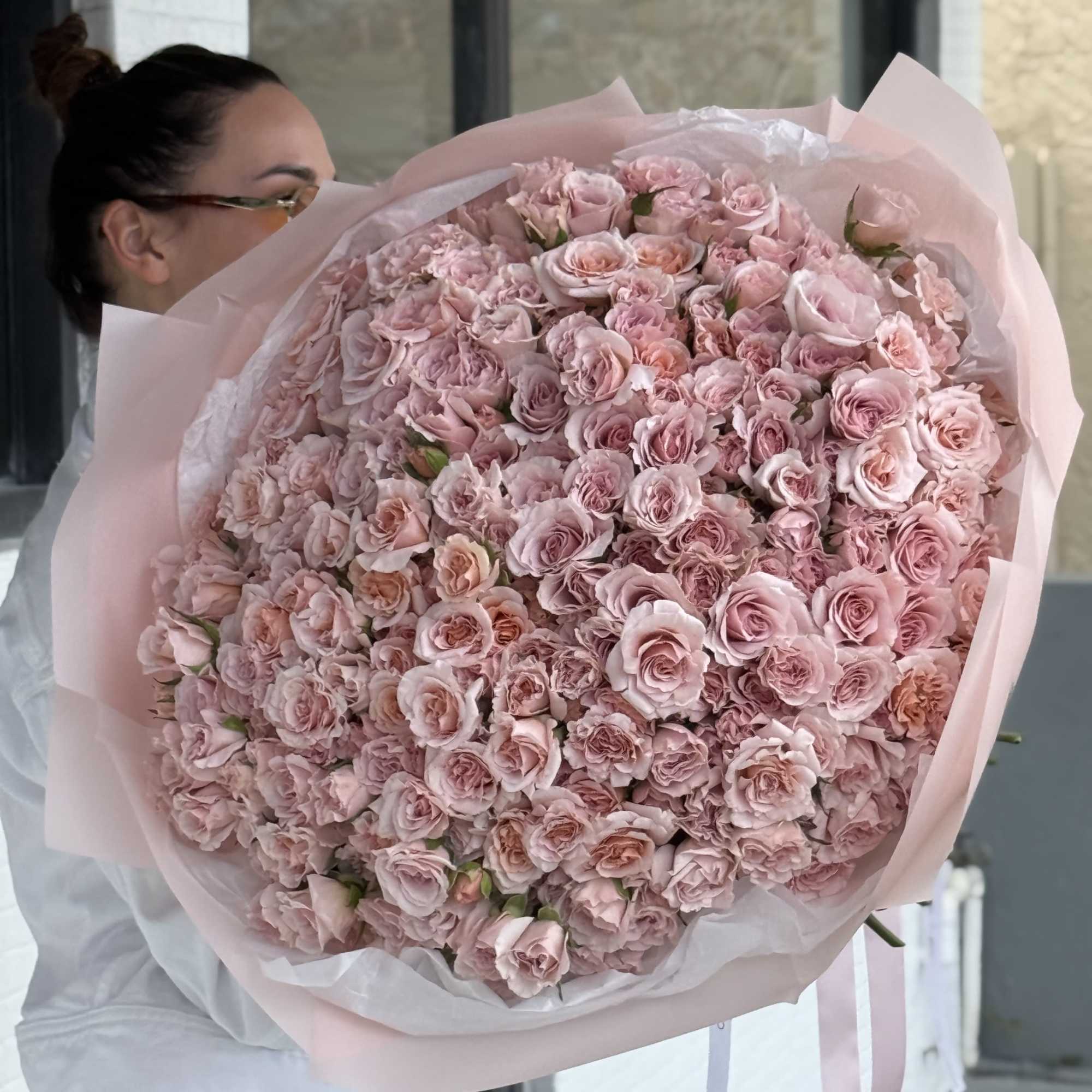 Large bouquet of pale pink roses wrapped in blush paper
