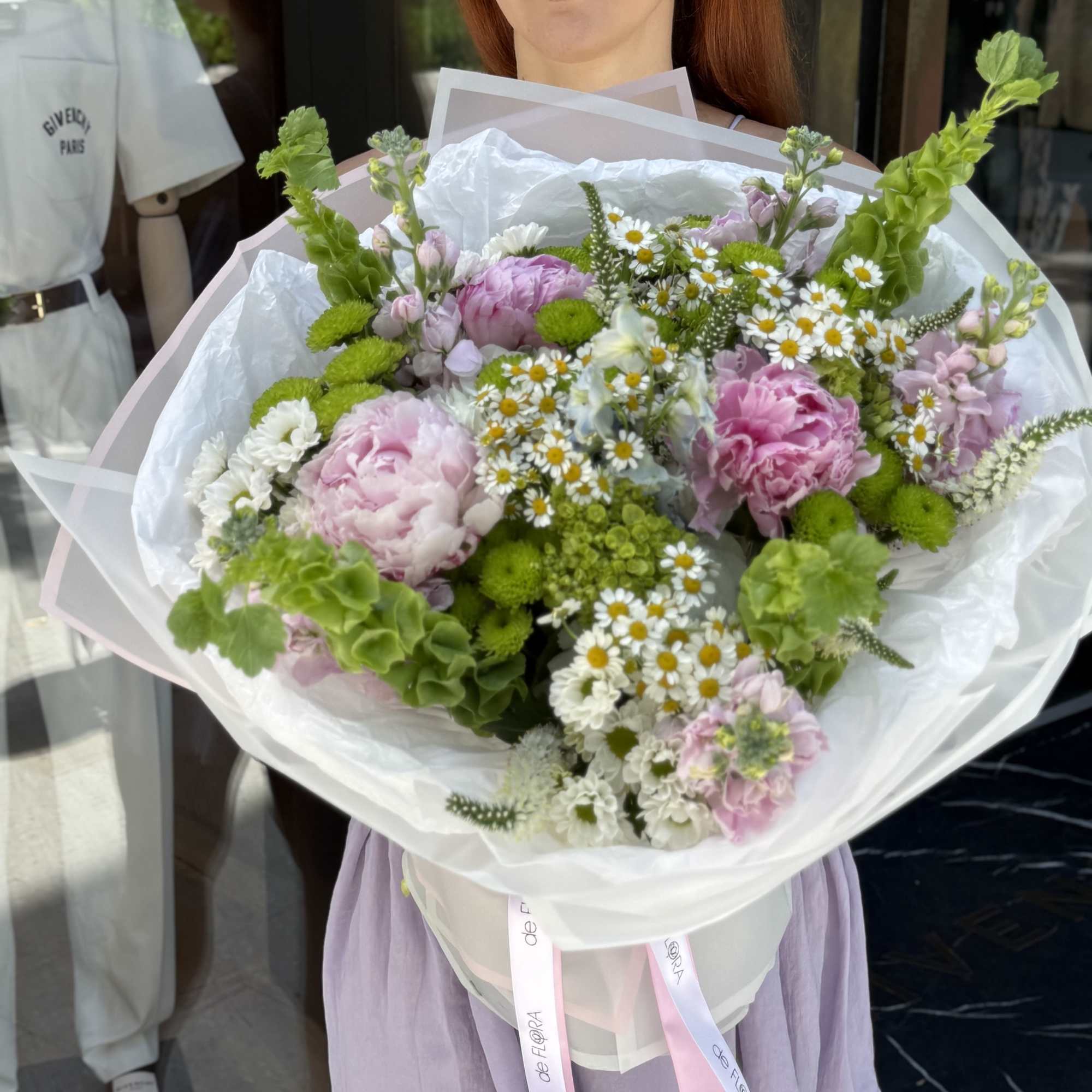 Large bouquet of pink and white flowers wrapped in white paper