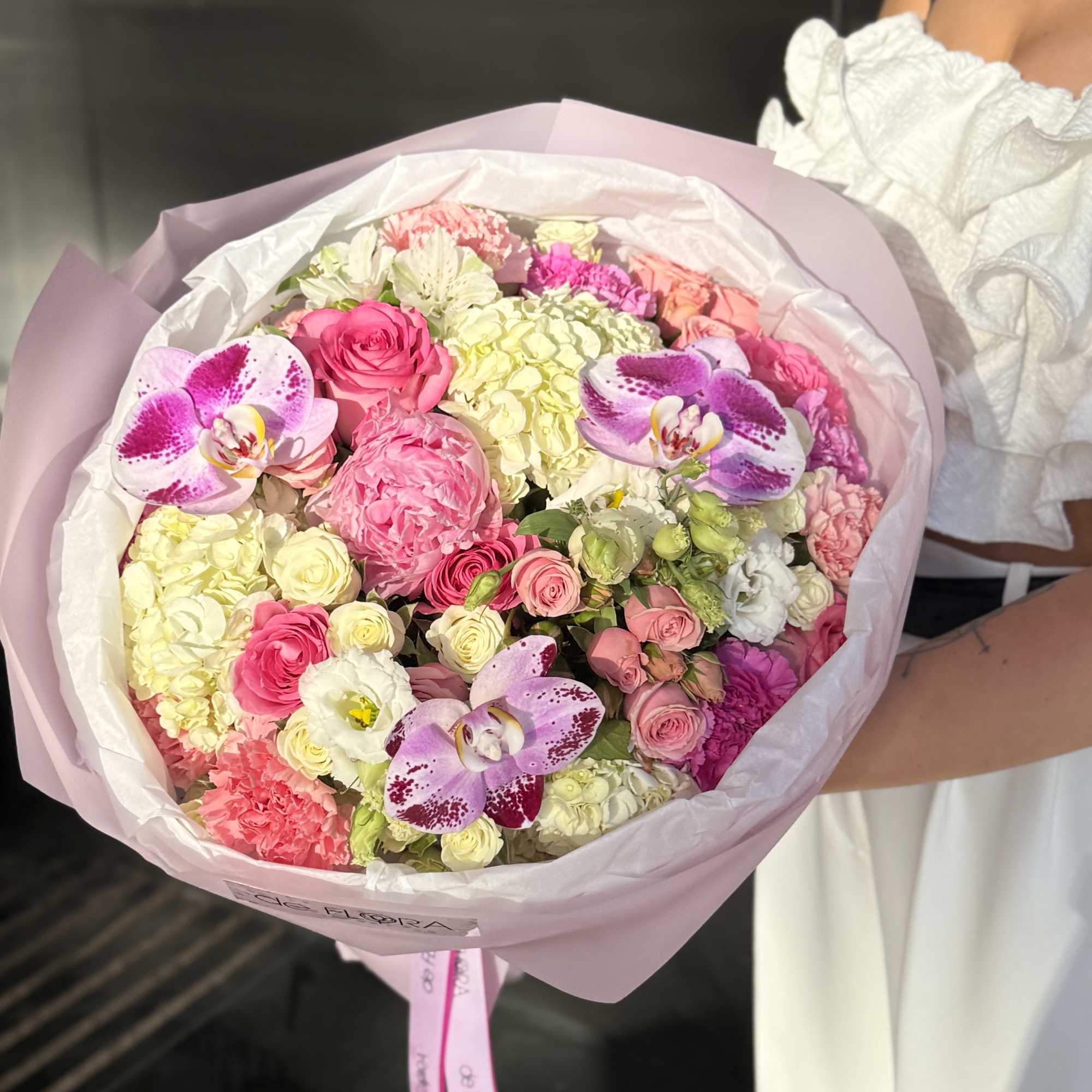 Pink and white mixed bouquet with orchids and roses wrapped in pale pink paper, photo 4 of 4