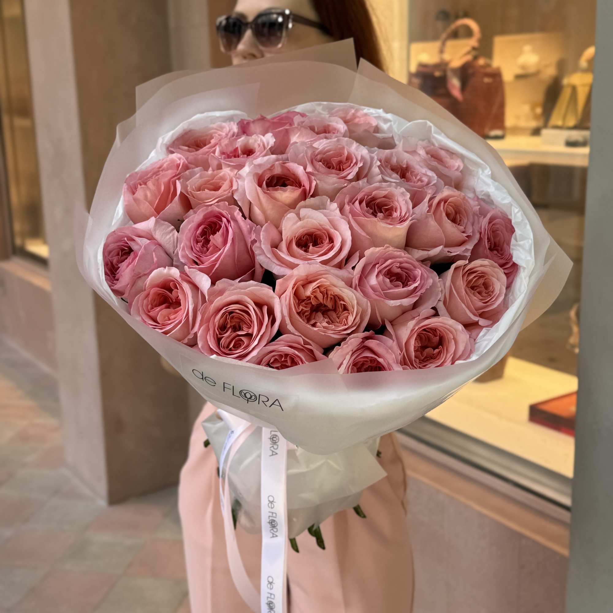 Large bouquet of pink roses wrapped in white paper
