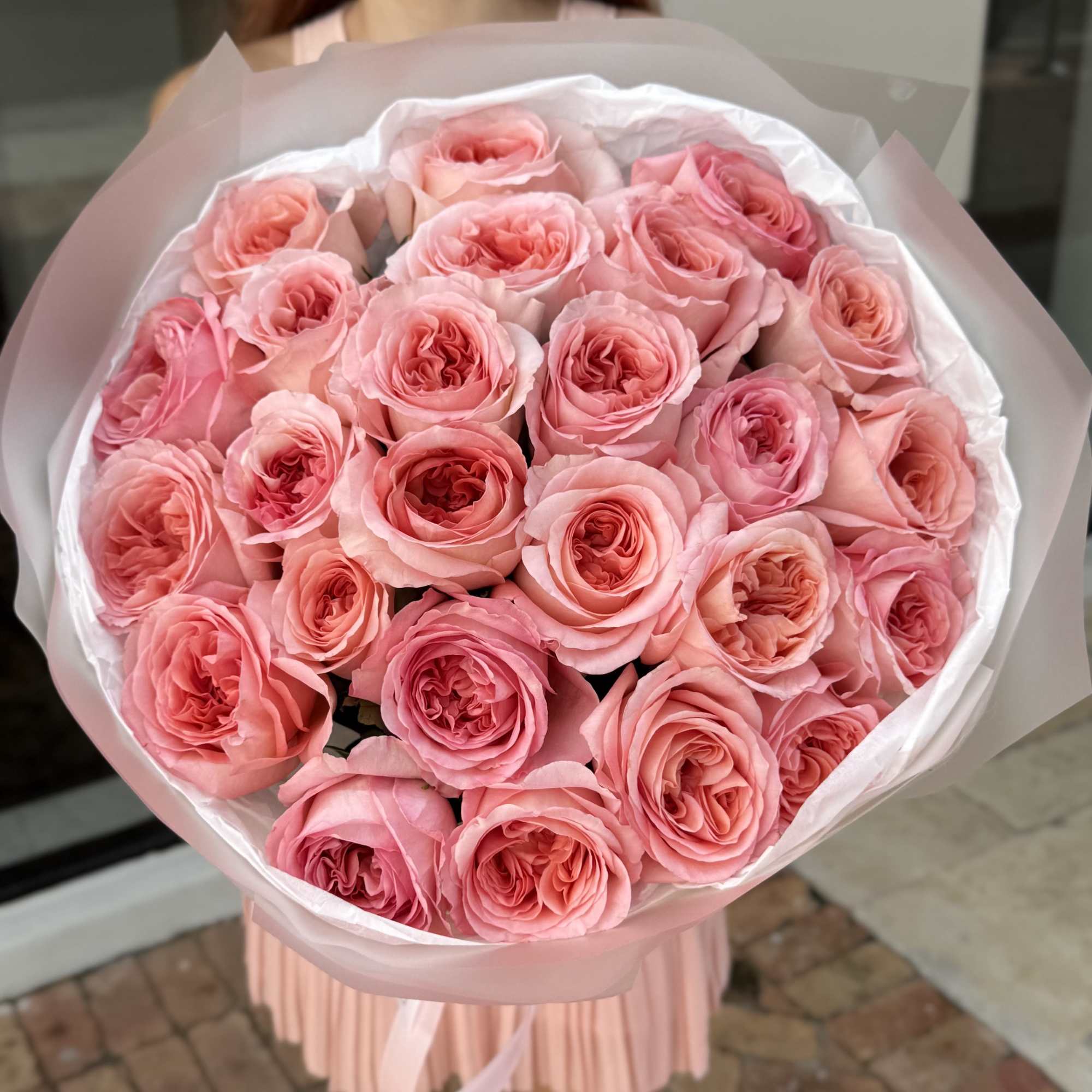 Large bouquet of pink roses wrapped in pale pink paper