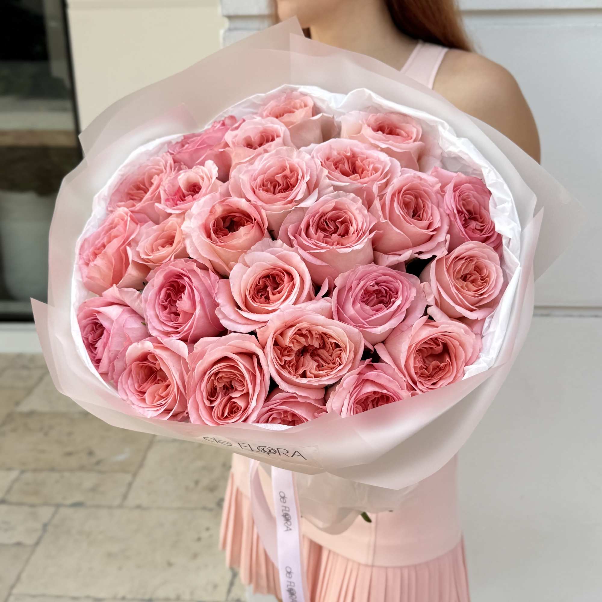Large bouquet of pink roses wrapped in pale pink paper