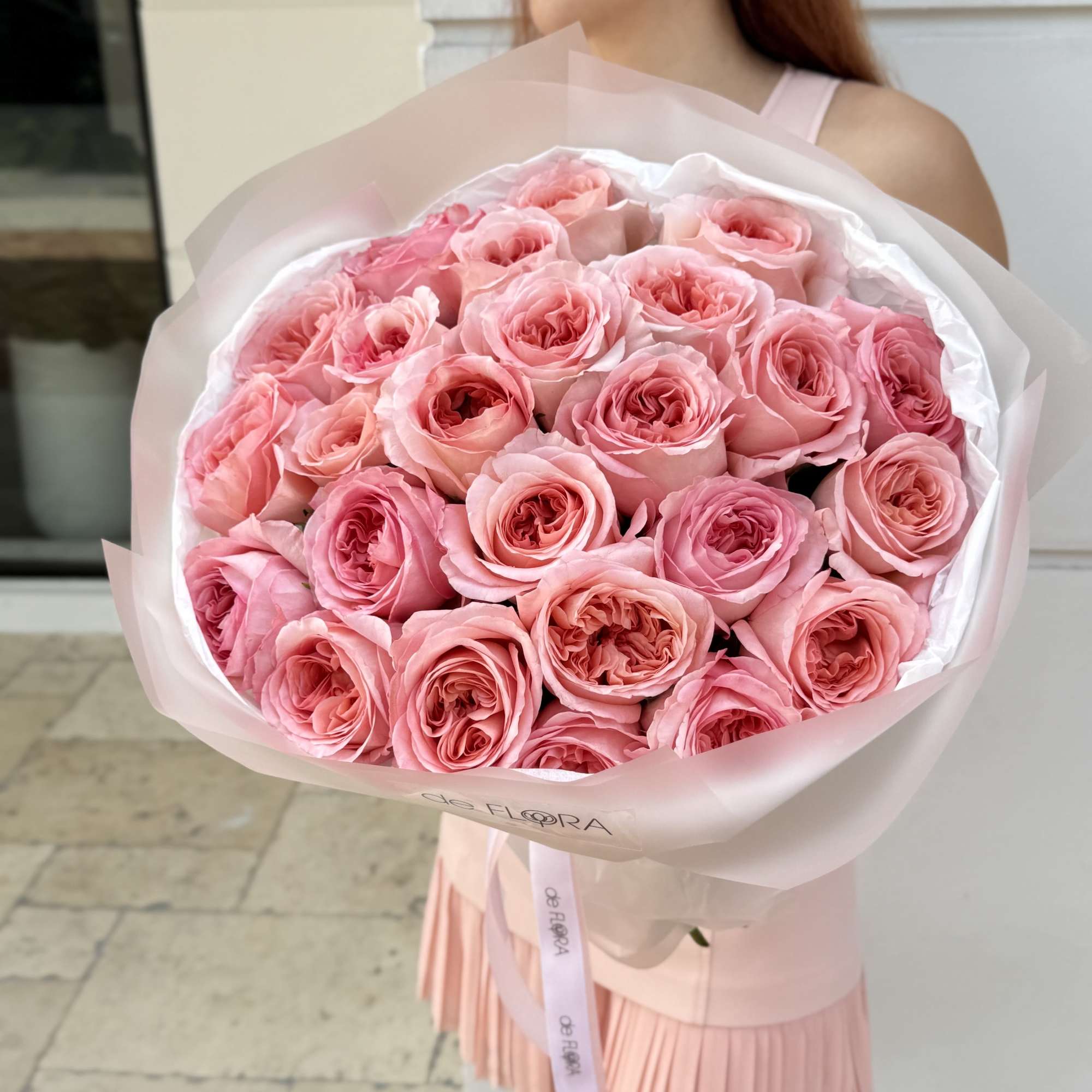 Large bouquet of pink roses wrapped in pale pink paper