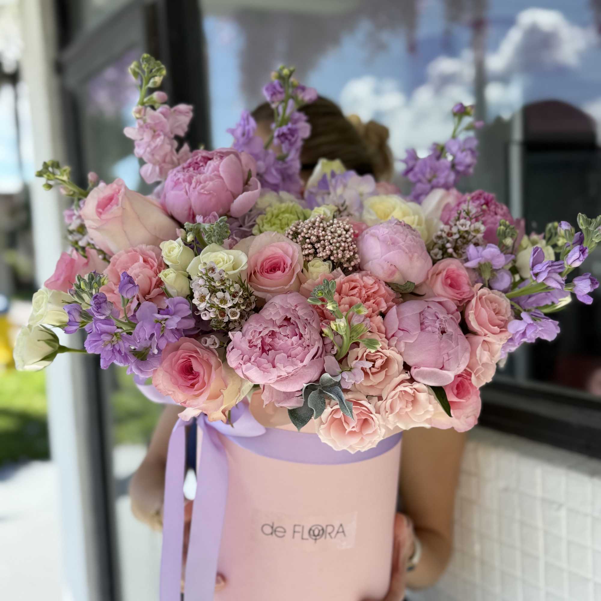 Large pastel bouquet in a pink hat box with lavender ribbon