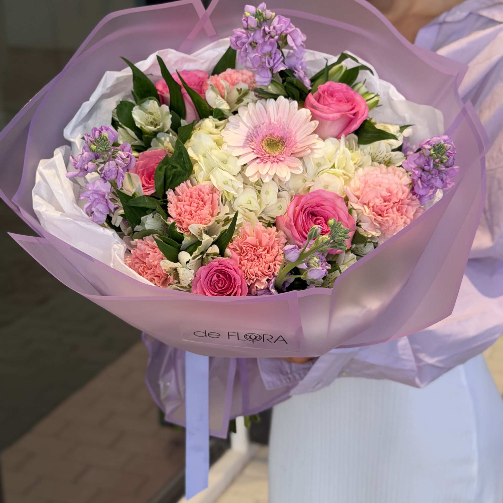 Pink and lavender mixed bouquet wrapped in translucent paper