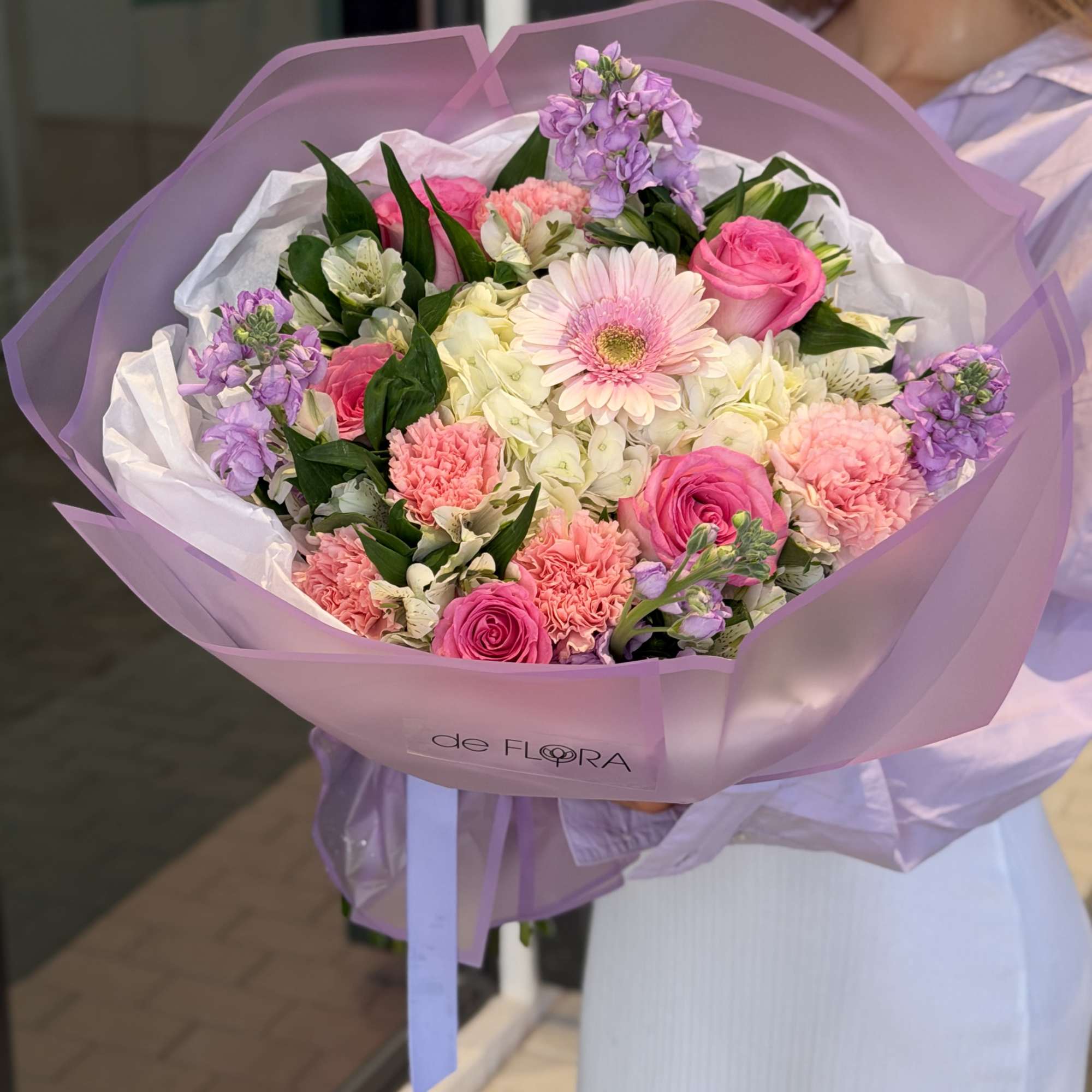 Pink and lavender mixed bouquet wrapped in translucent paper