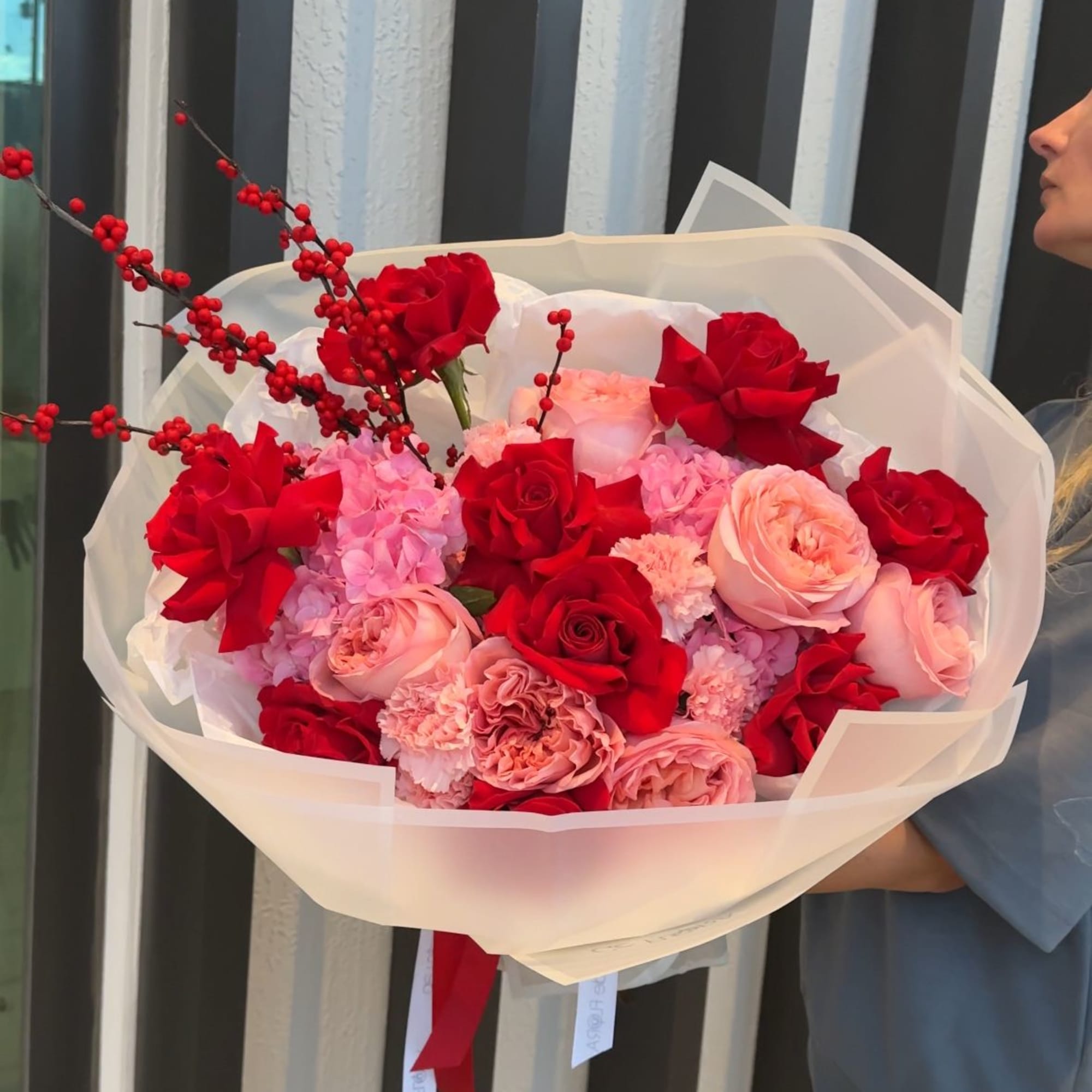 Bouquet of red and pink roses wrapped in white paper
