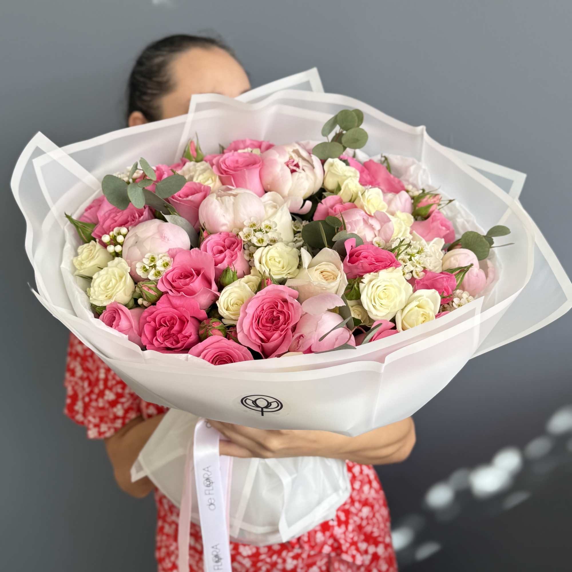 Large bouquet of pink and white roses wrapped in white paper