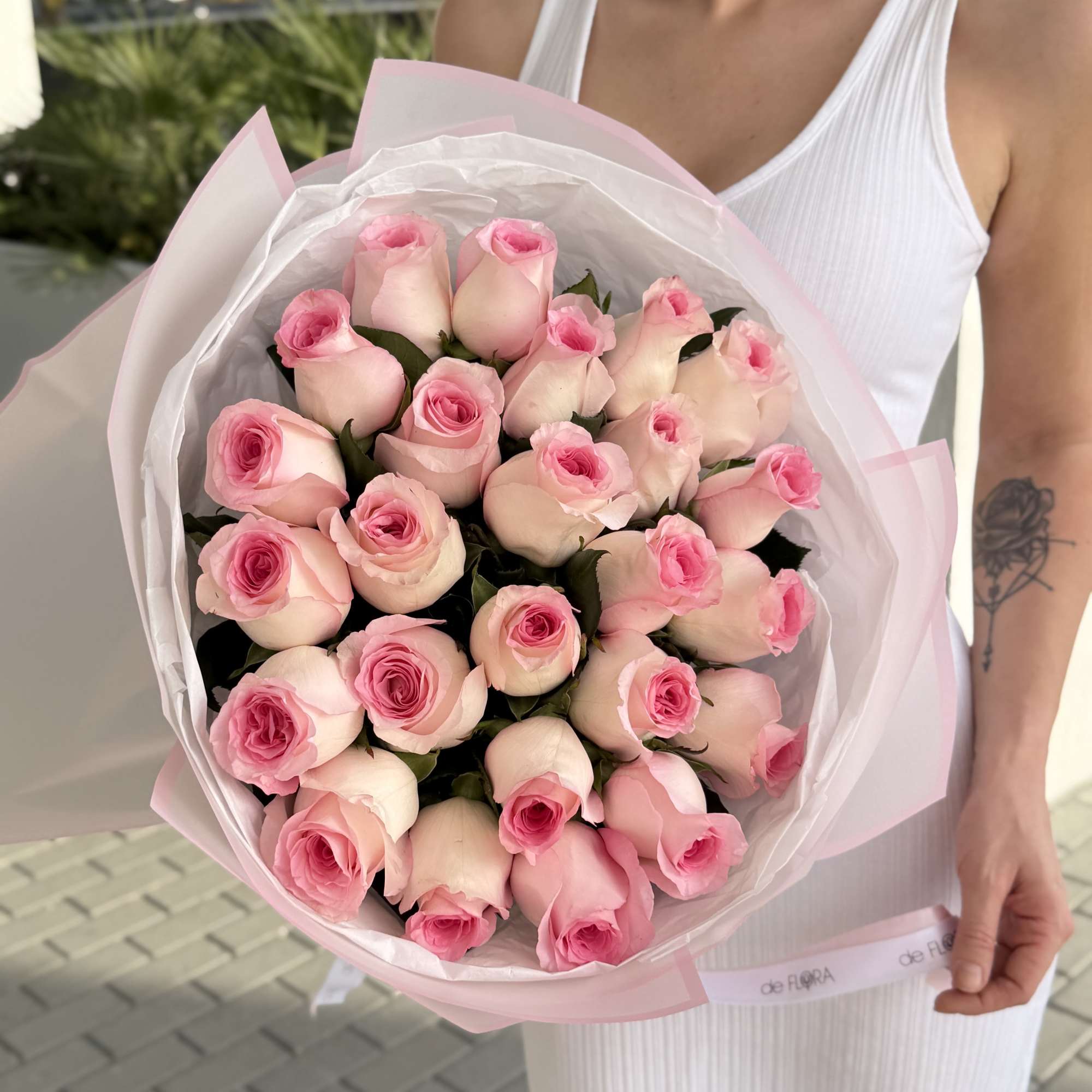Bouquet of pale pink roses wrapped in white and pink paper