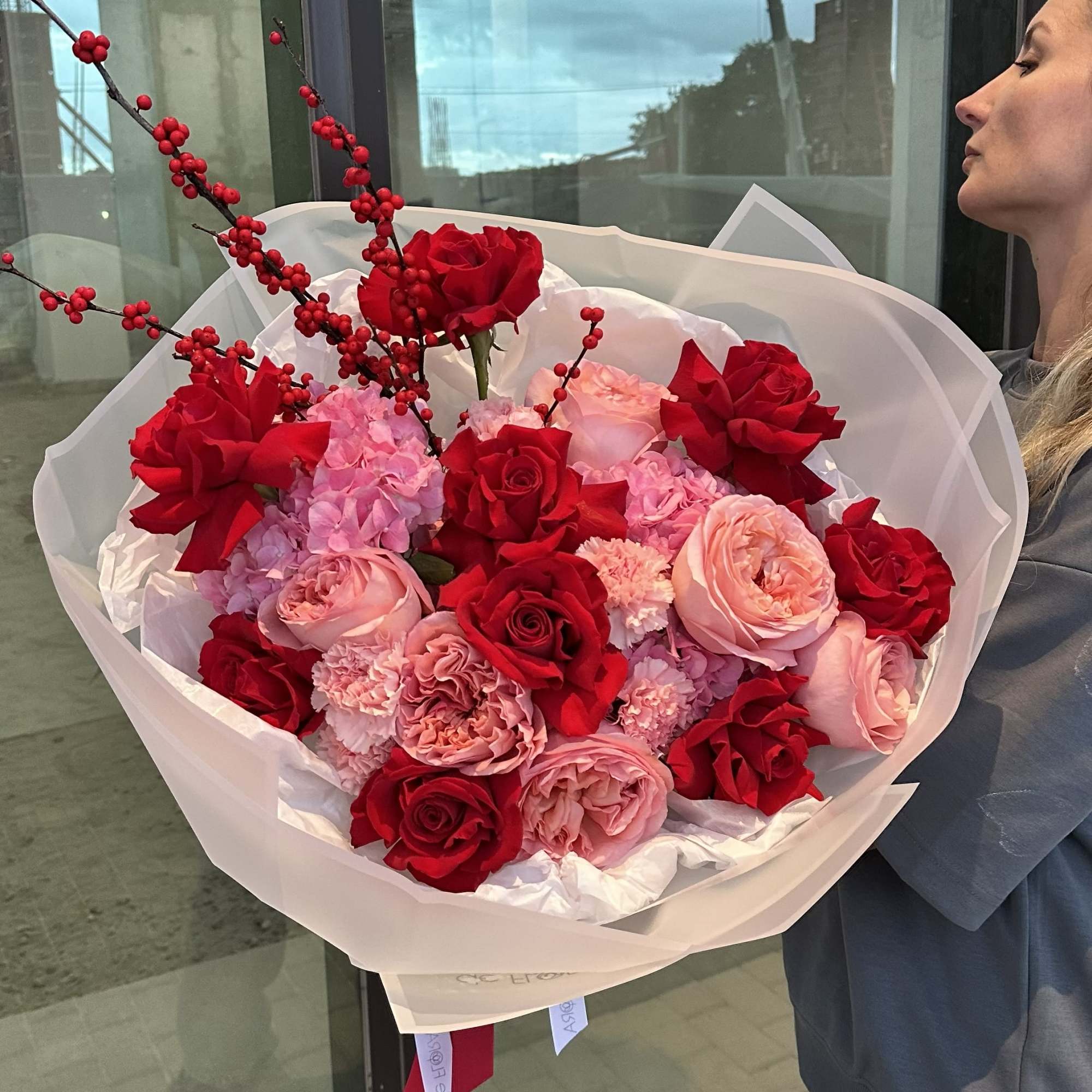 Large bouquet of red and pink roses with berry branches