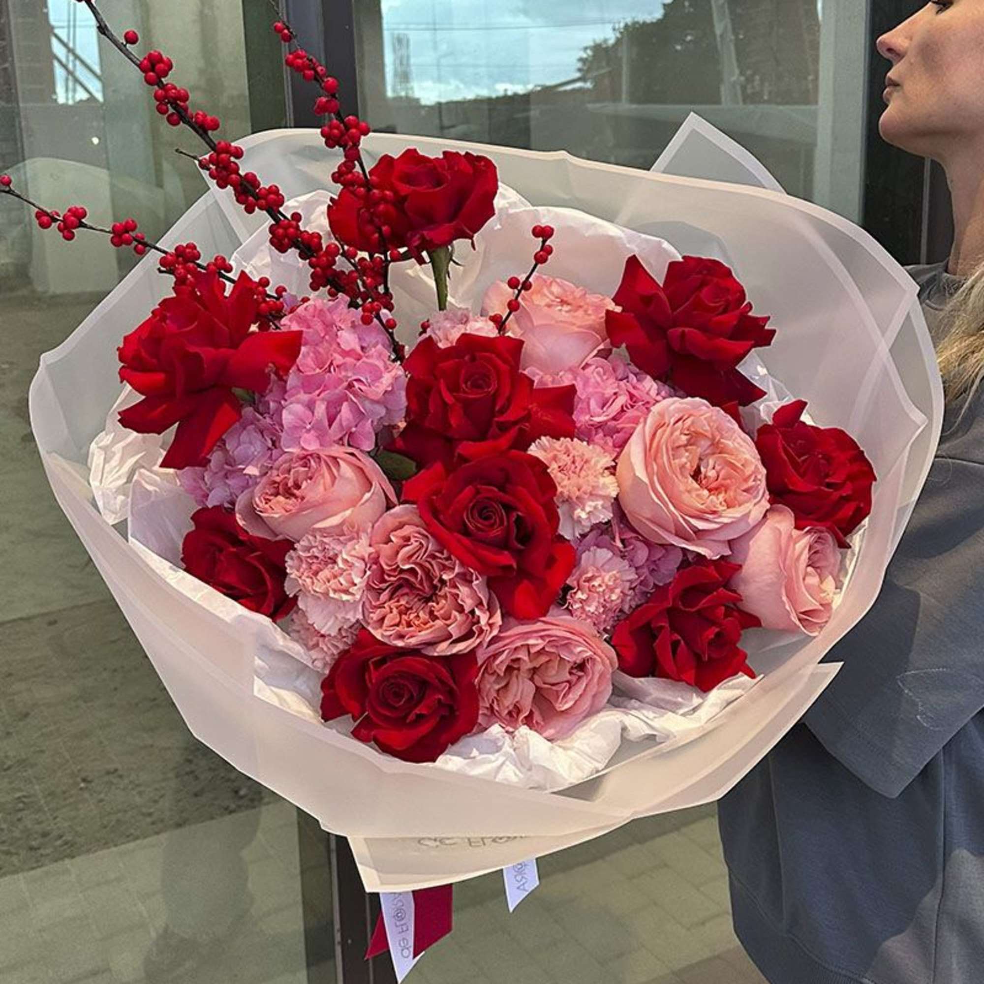 Large bouquet of red and pink roses with berry branches