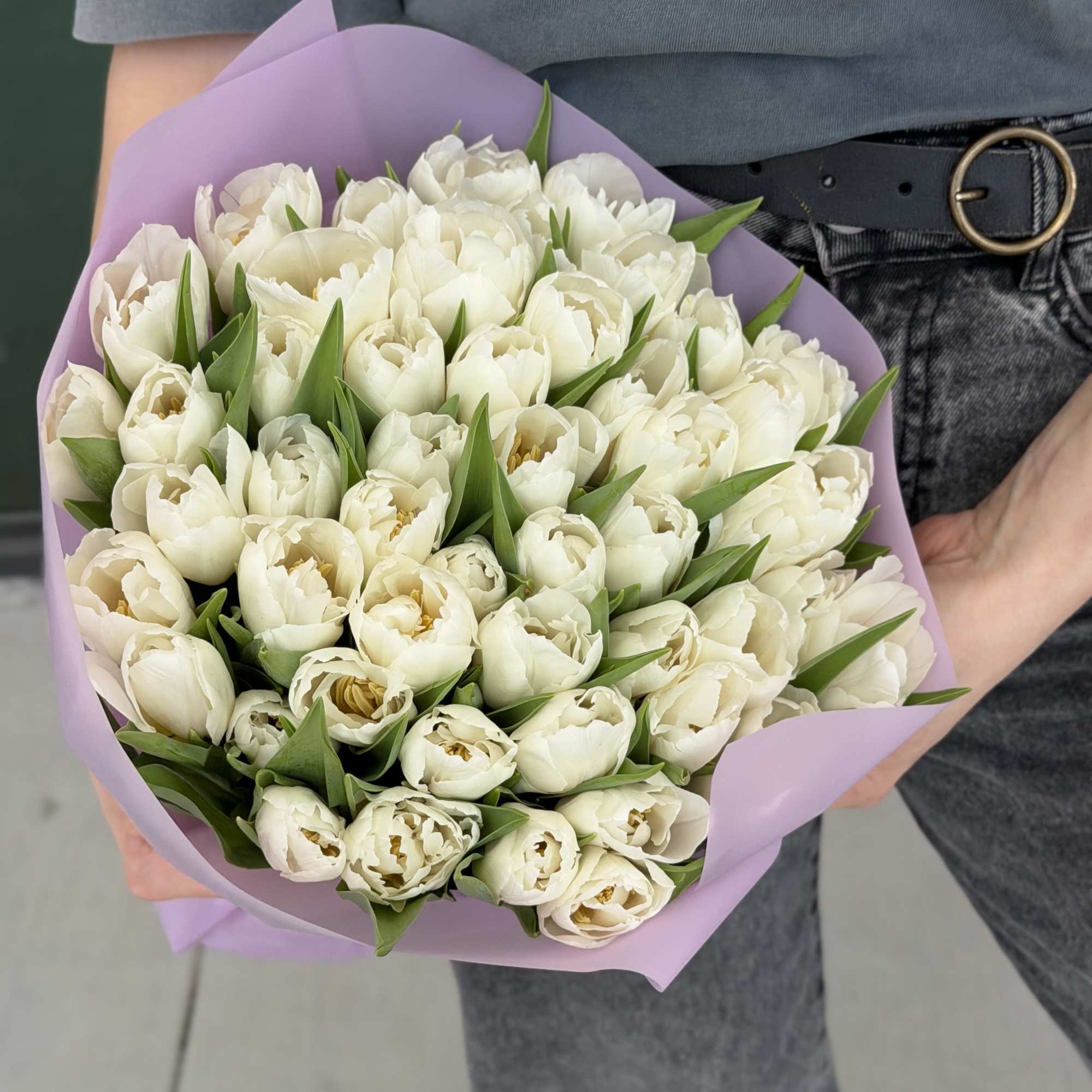 Bouquet of white tulips wrapped in lavender paper