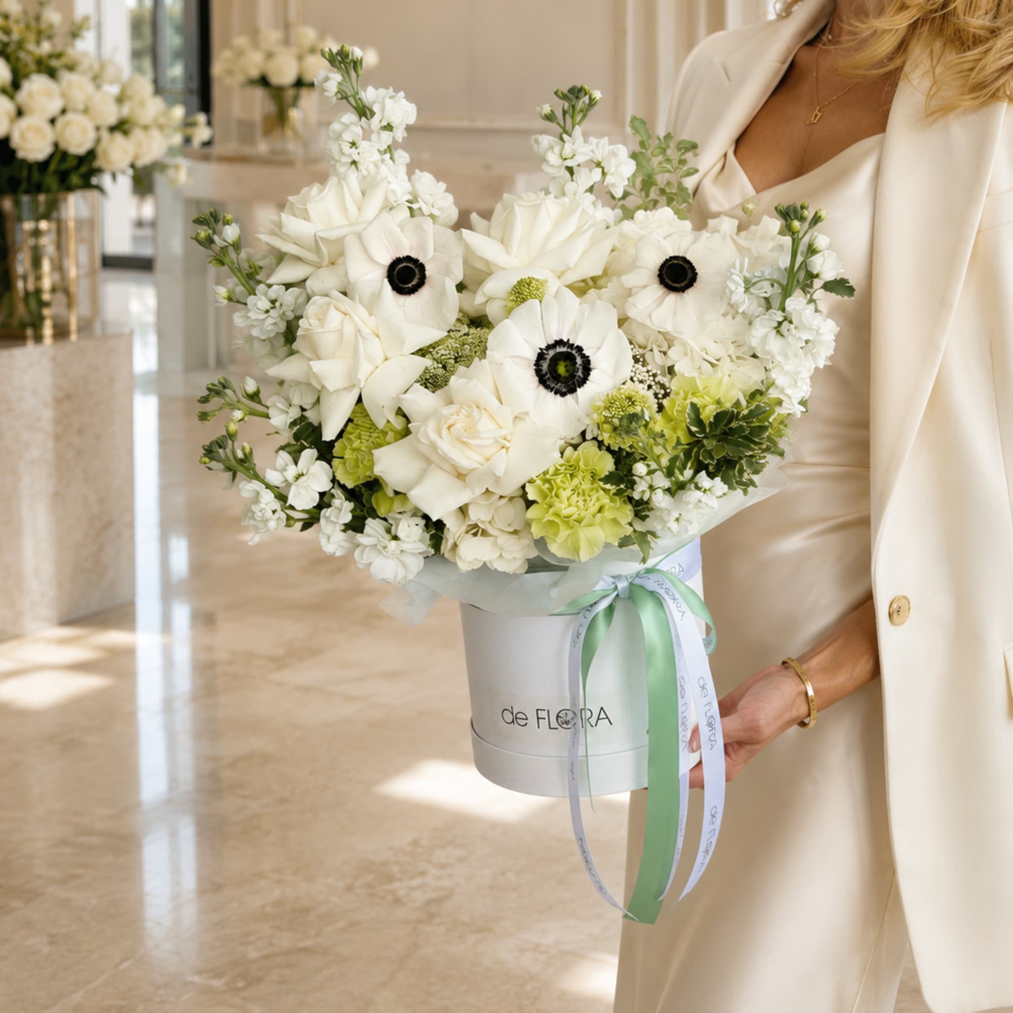An exquisite arrangement of creamy white roses, delicate anemones with deep contrasting