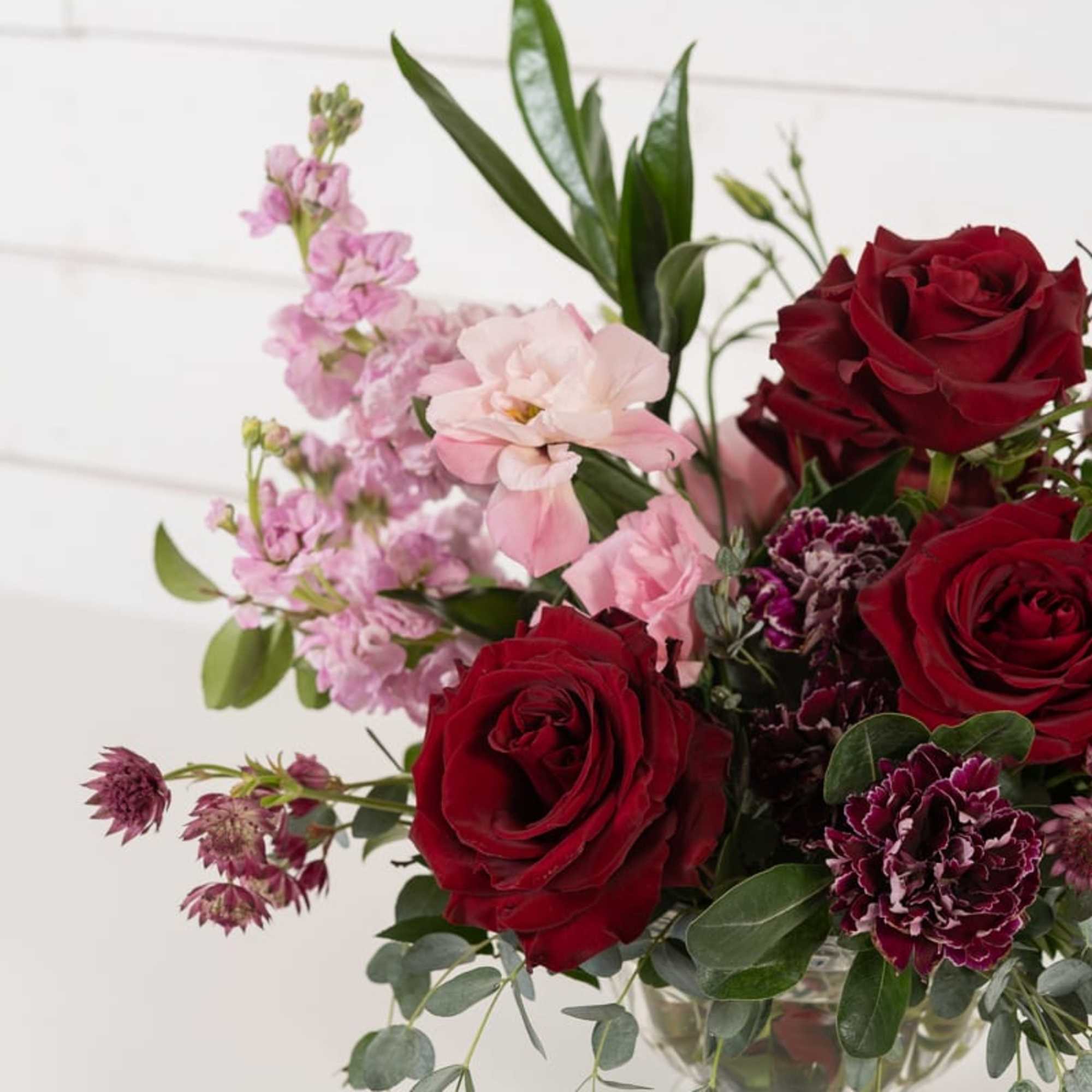 Bouquet of red and pink flowers in a clear glass vase