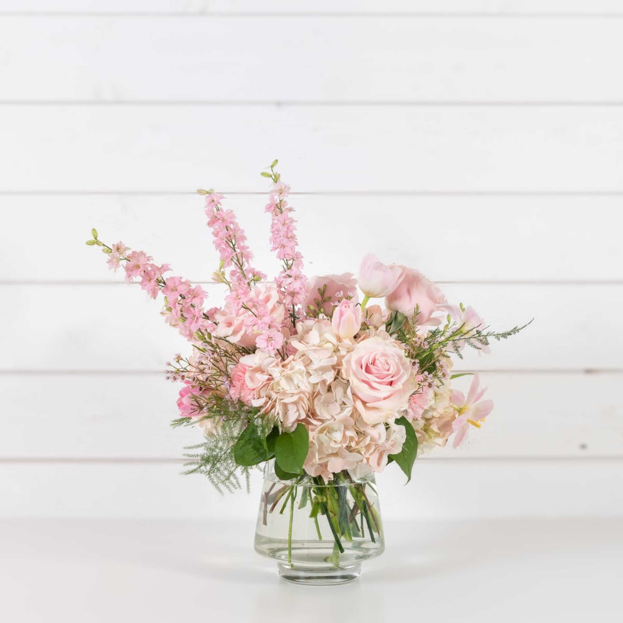 Pink and white floral arrangement in a clear glass vase