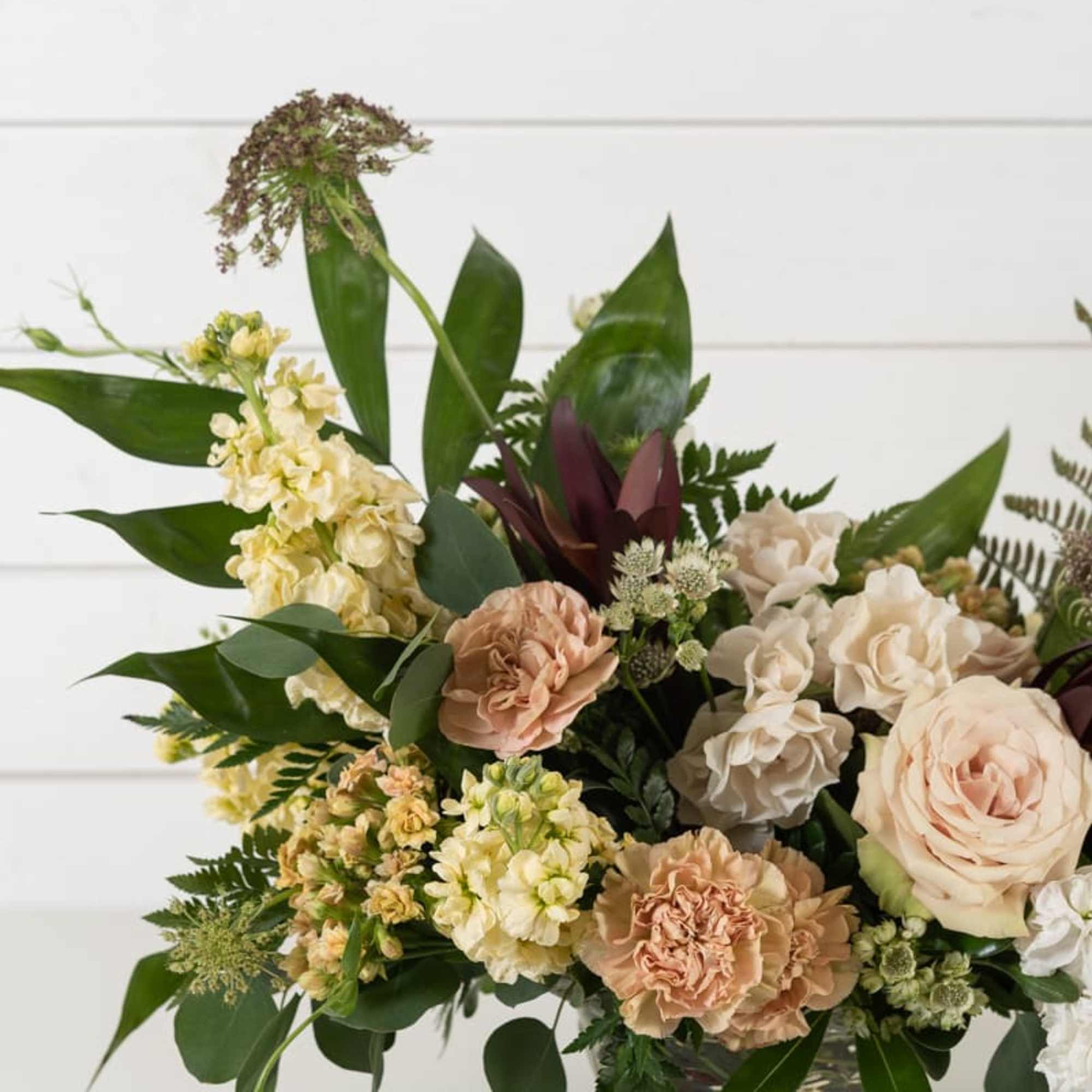 Blush and cream floral arrangement in a clear glass vase