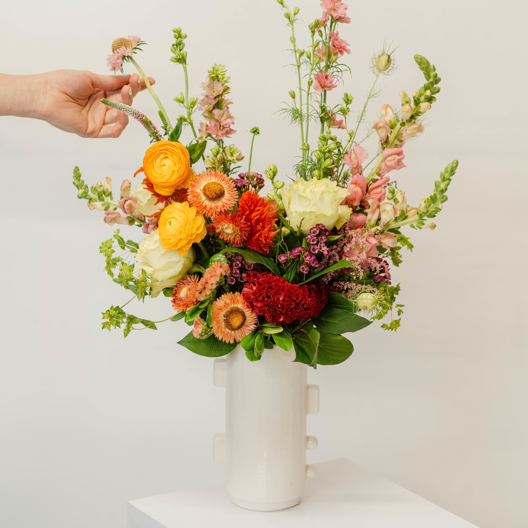 Colorful mixed flower arrangement in a white vase