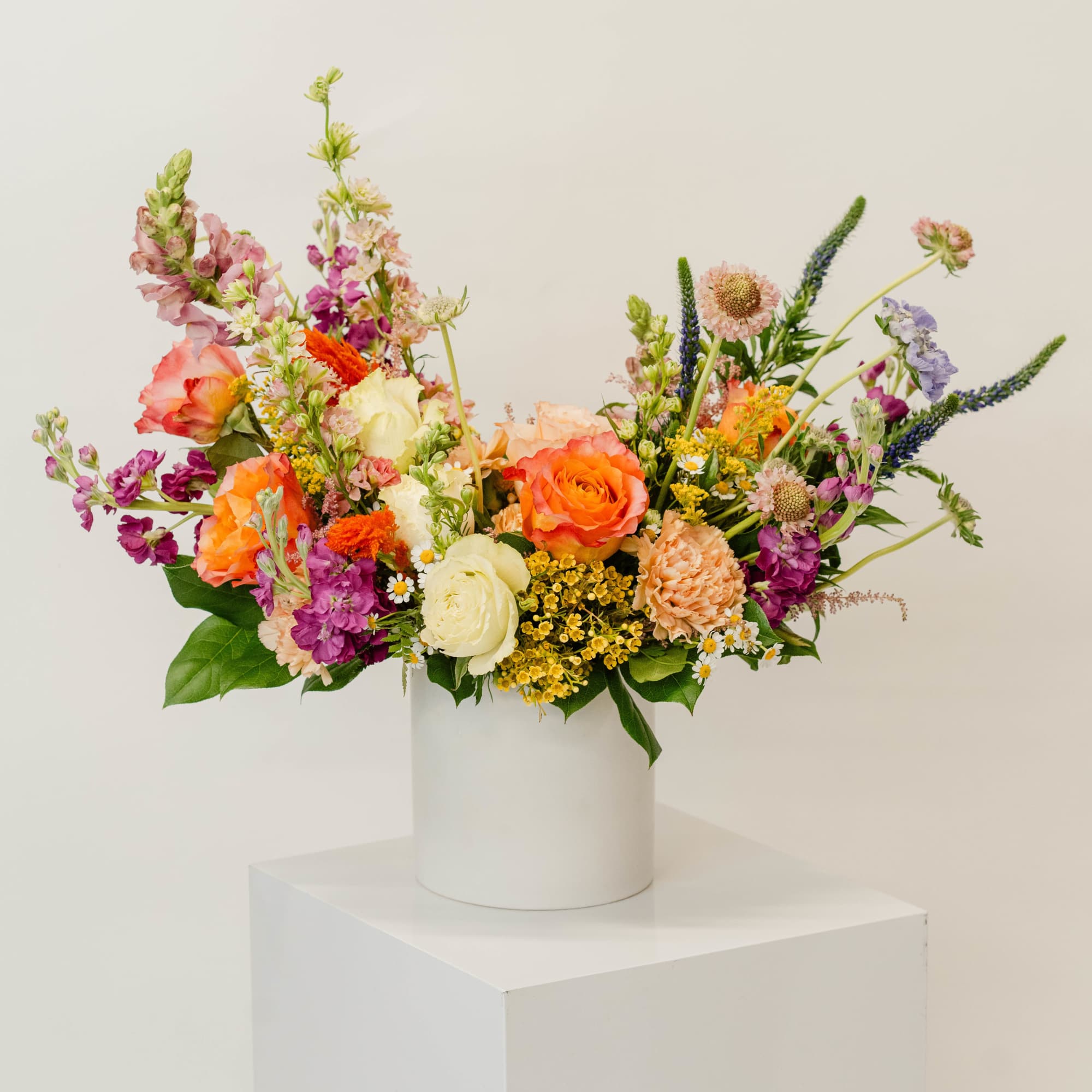 Colorful mixed bouquet in a white cylindrical vase