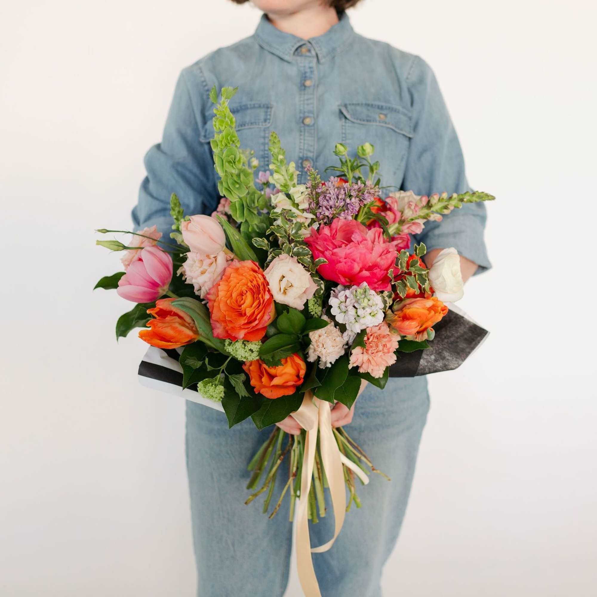 A stunning, premium hand-tied arrangement including coral charm peonies, fluffy lisianthus, lush