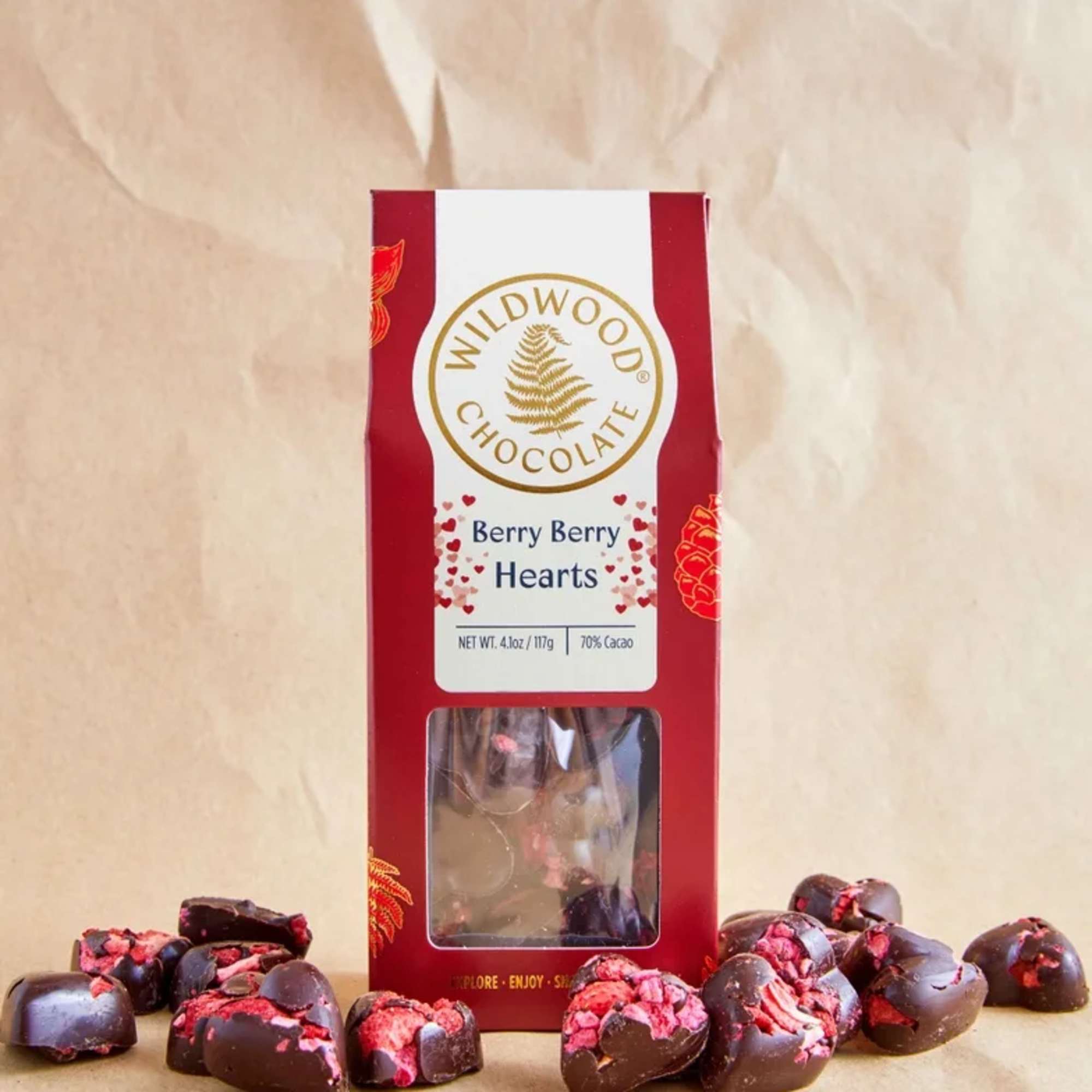 Box of berry chocolate hearts with pieces scattered around it