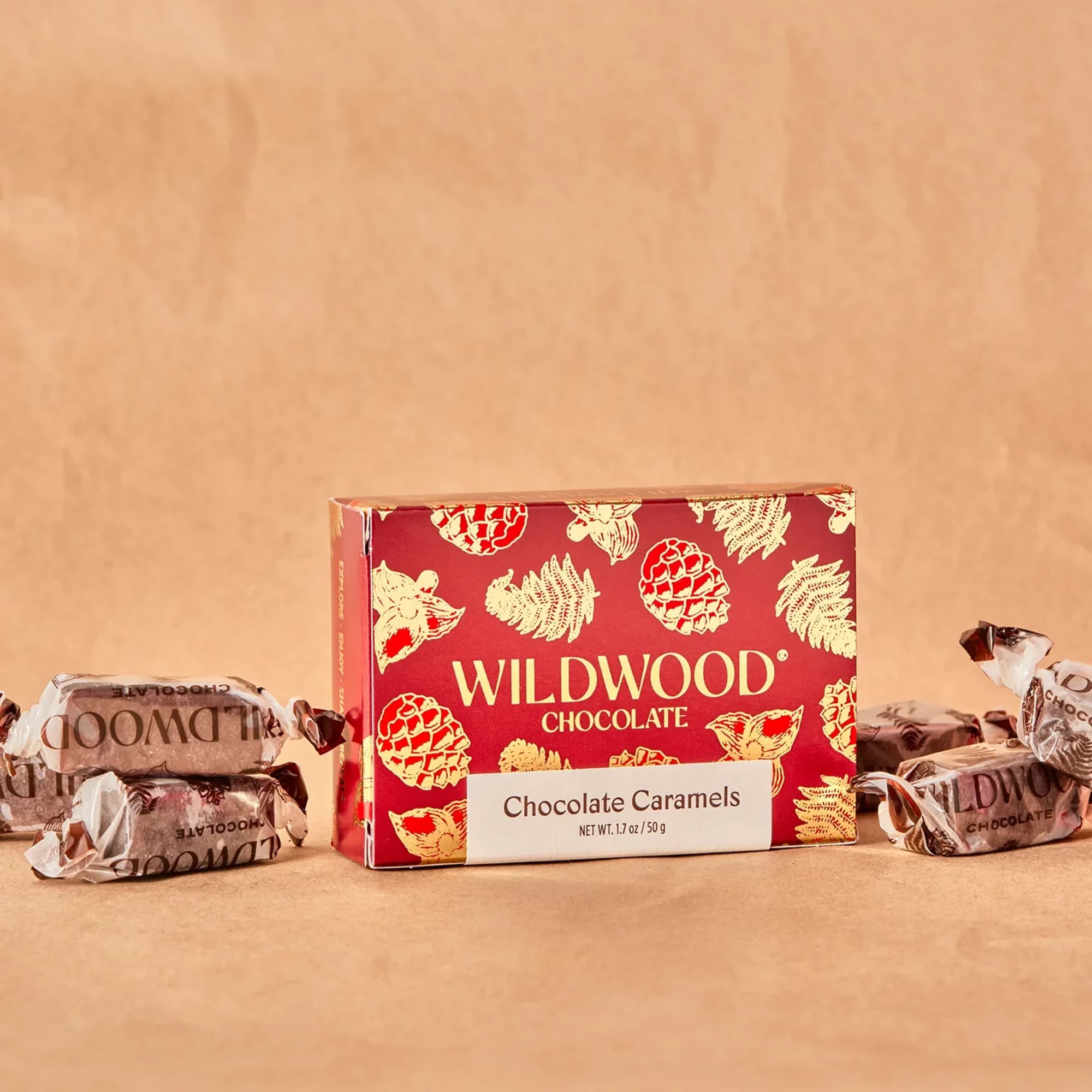Box of Wildwood chocolate caramels with wrapped candies on a tan background