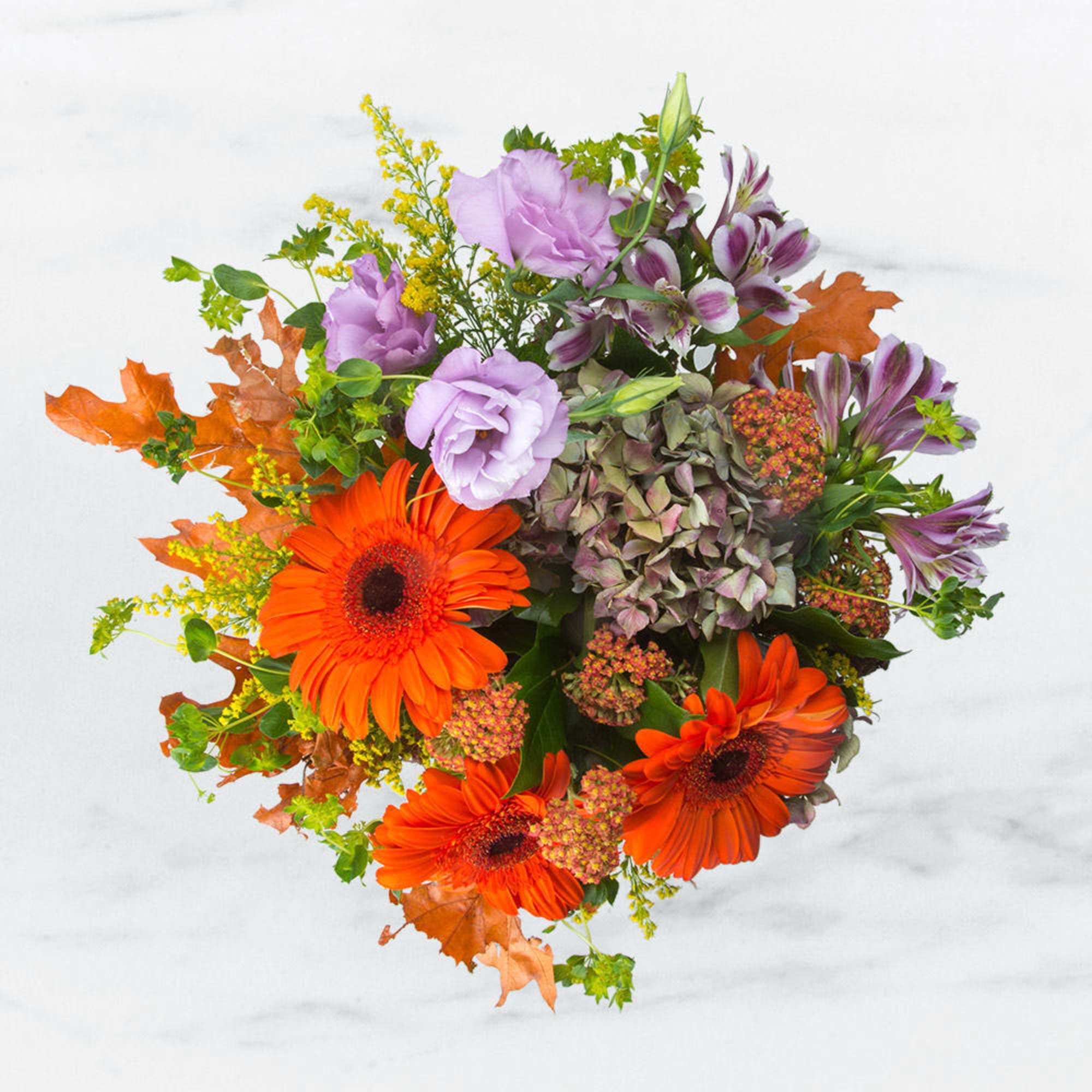 Bouquet with orange gerbera daisies, lavender blooms, and autumn leaves