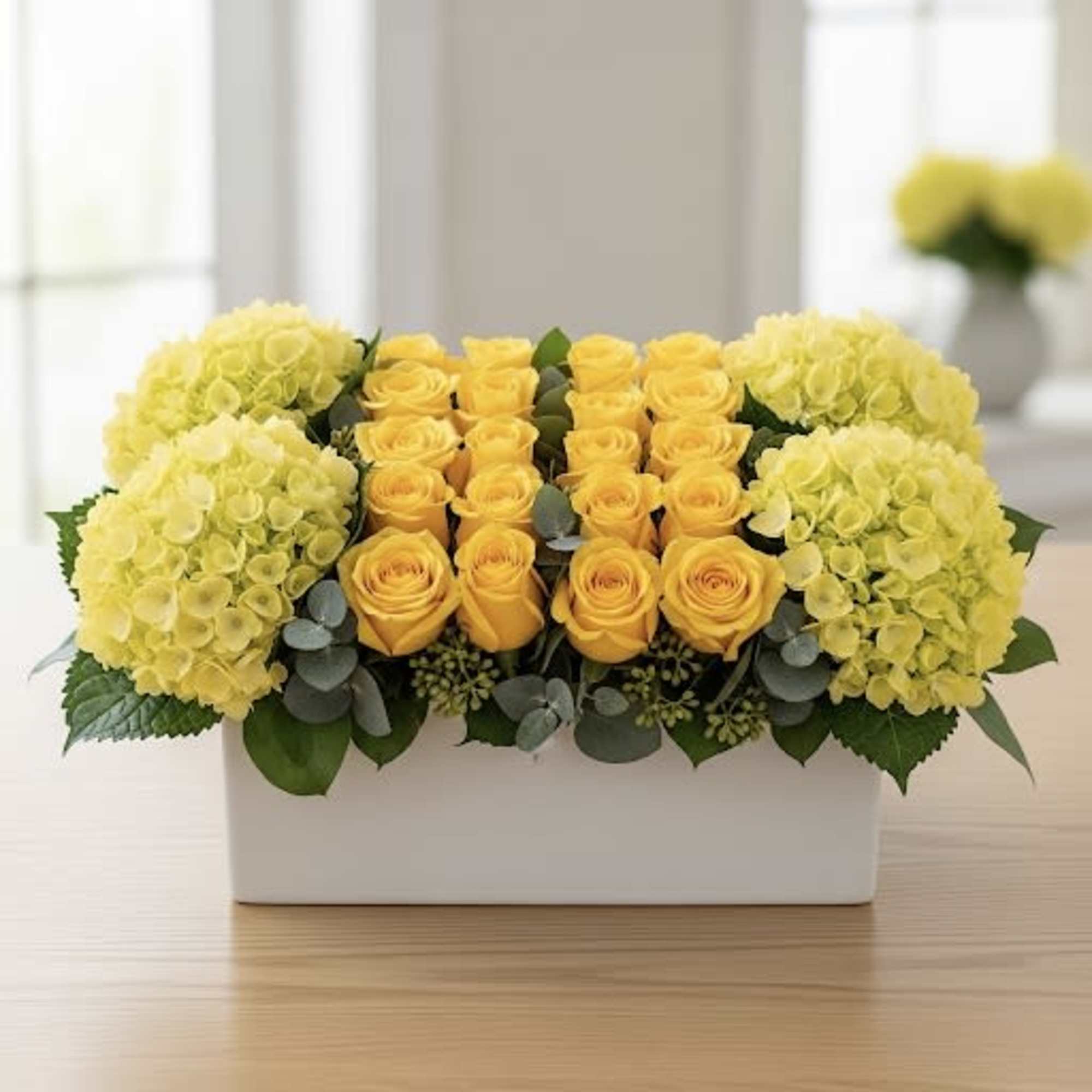 Yellow roses and hydrangeas arranged in a white rectangular box