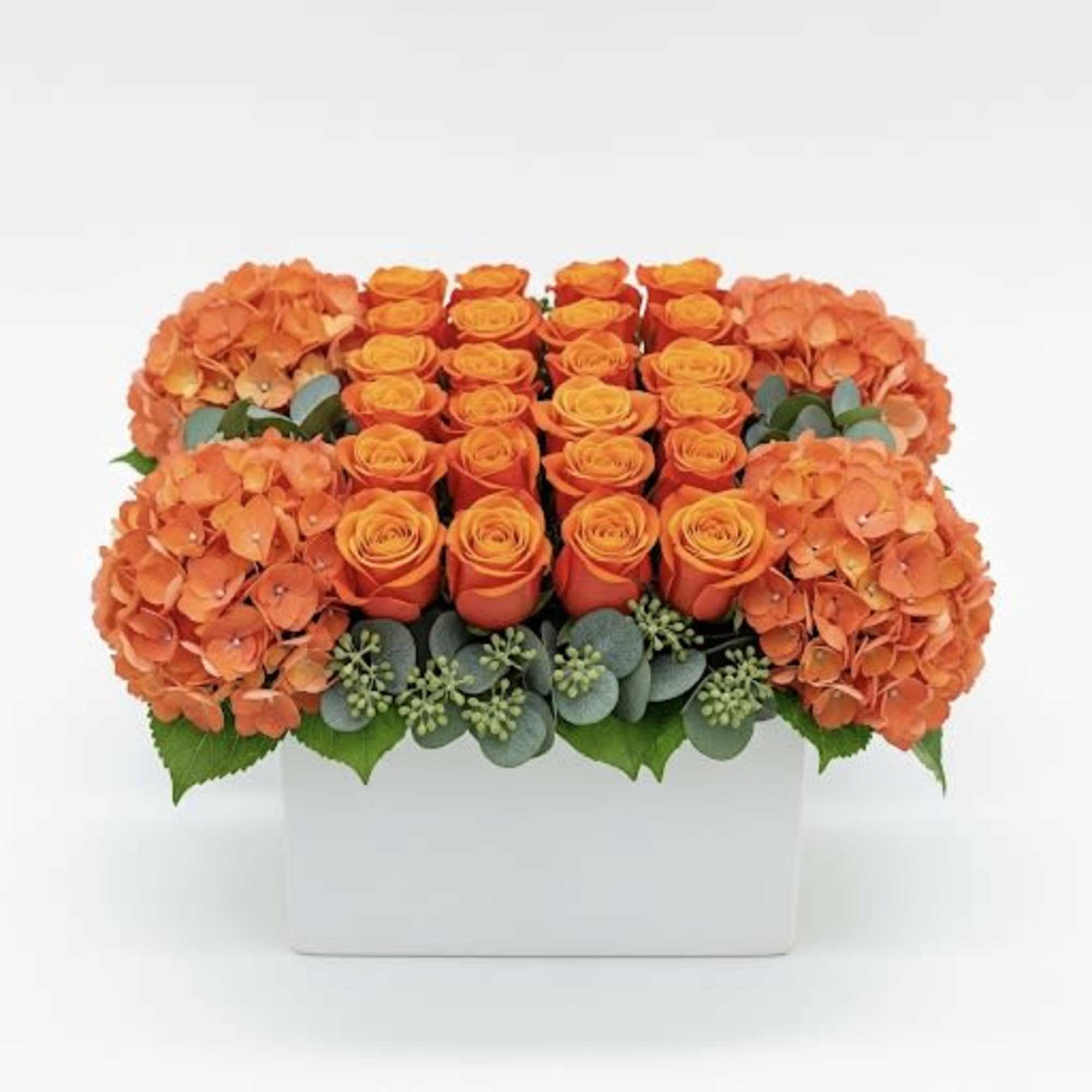Orange roses and hydrangeas in a white rectangular vase