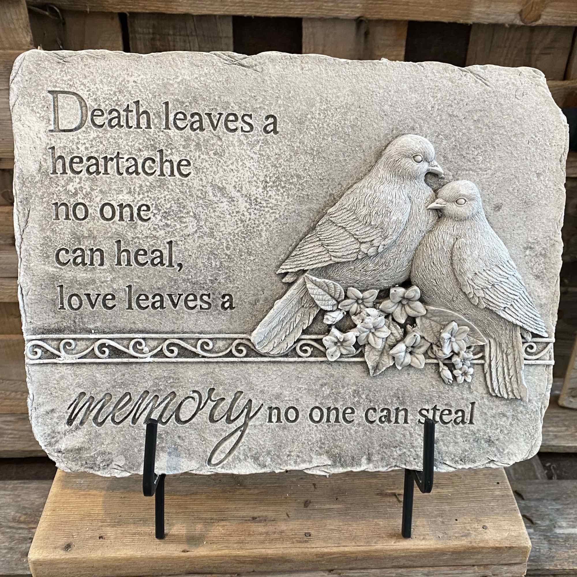 Stone memorial plaque with two birds and an engraved sympathy quote