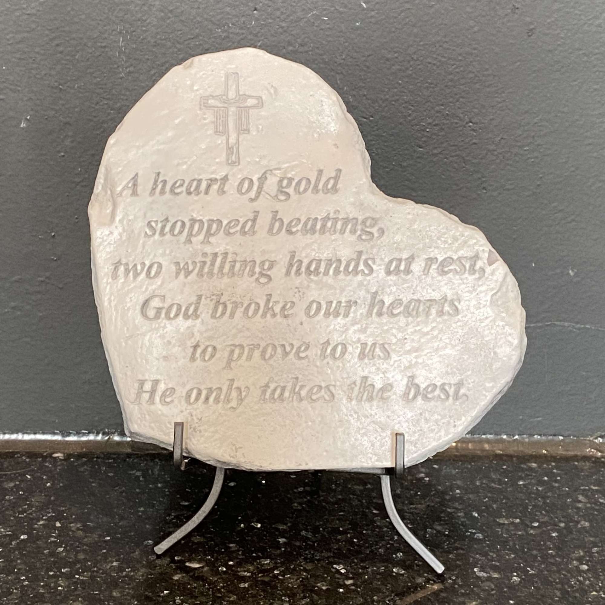 Heart-shaped memorial stone with engraved cross and verse on a stand