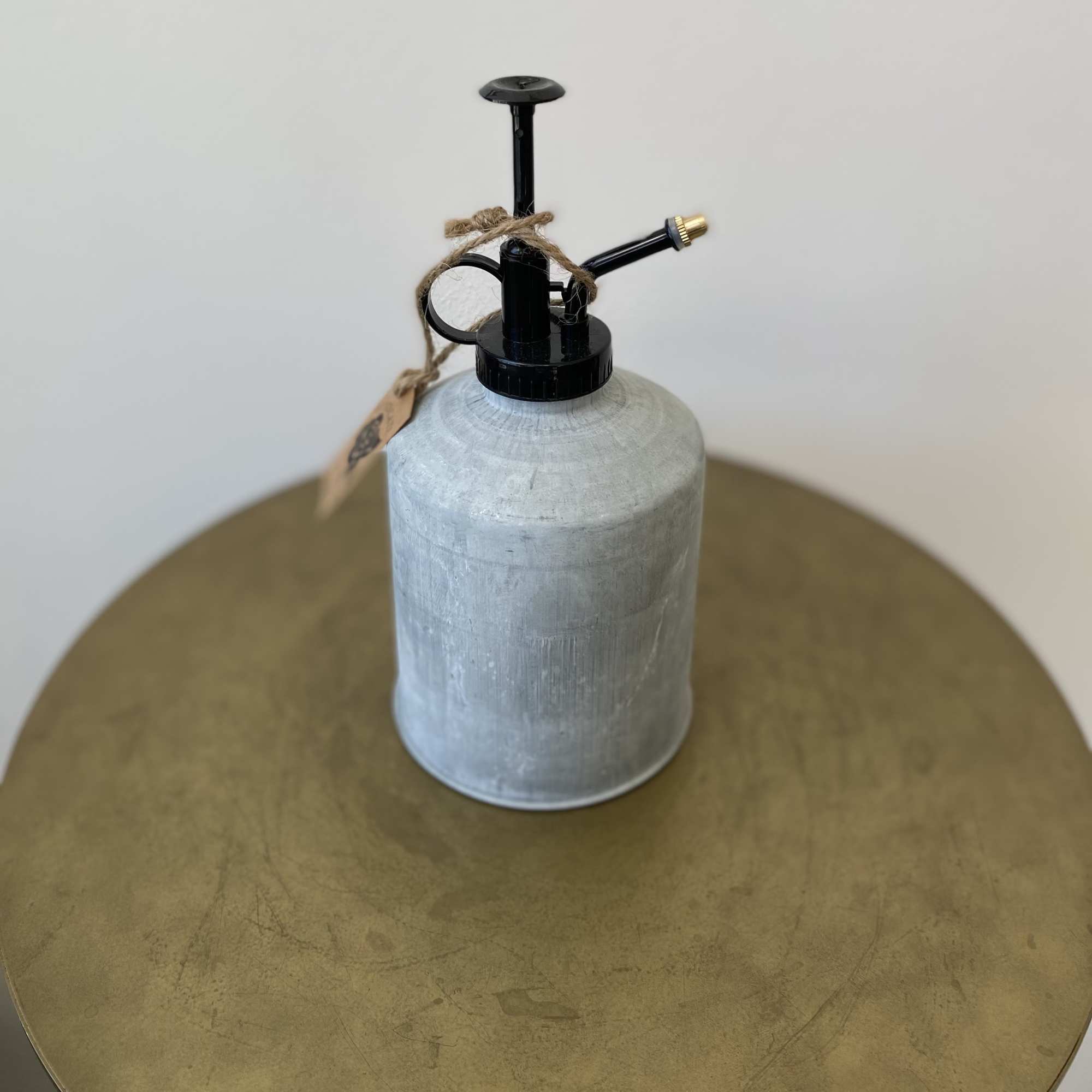 Metal watering can with black spout and twine tag