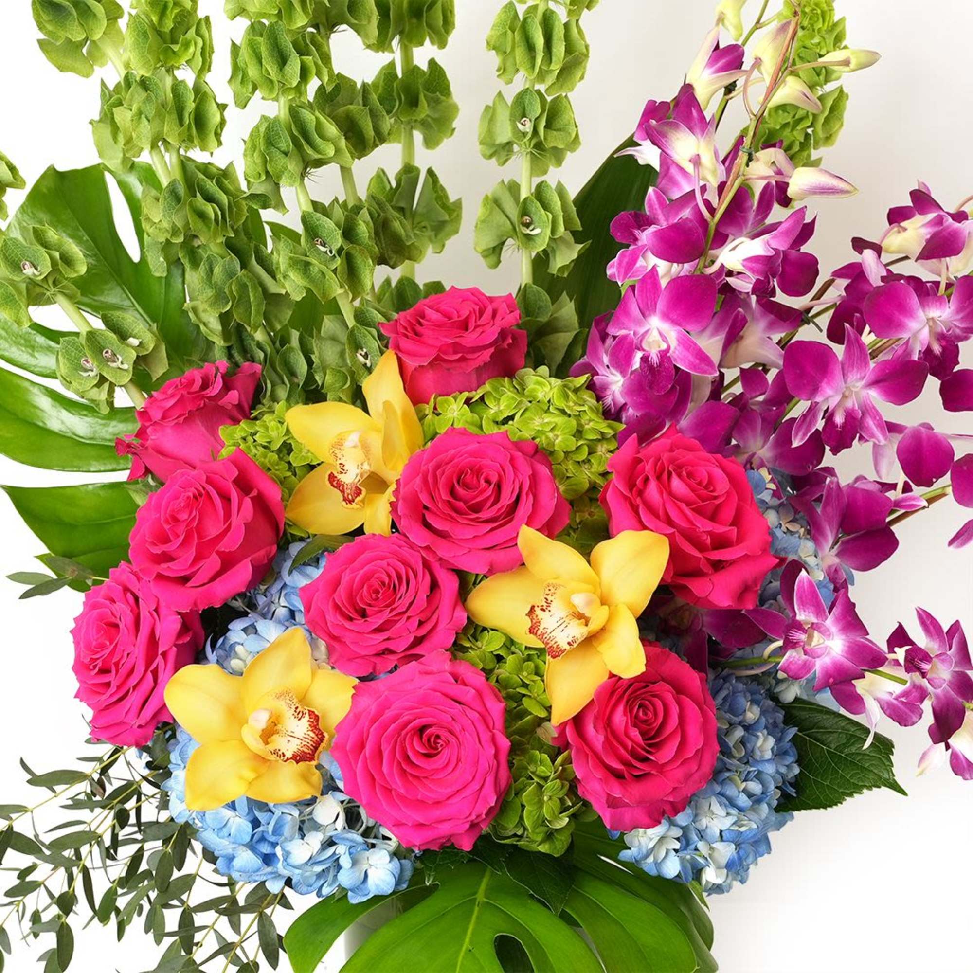 Tall, vibrant arrangement with hot pink roses, yellow orchids, purple orchids, and blue and green hydrangeas