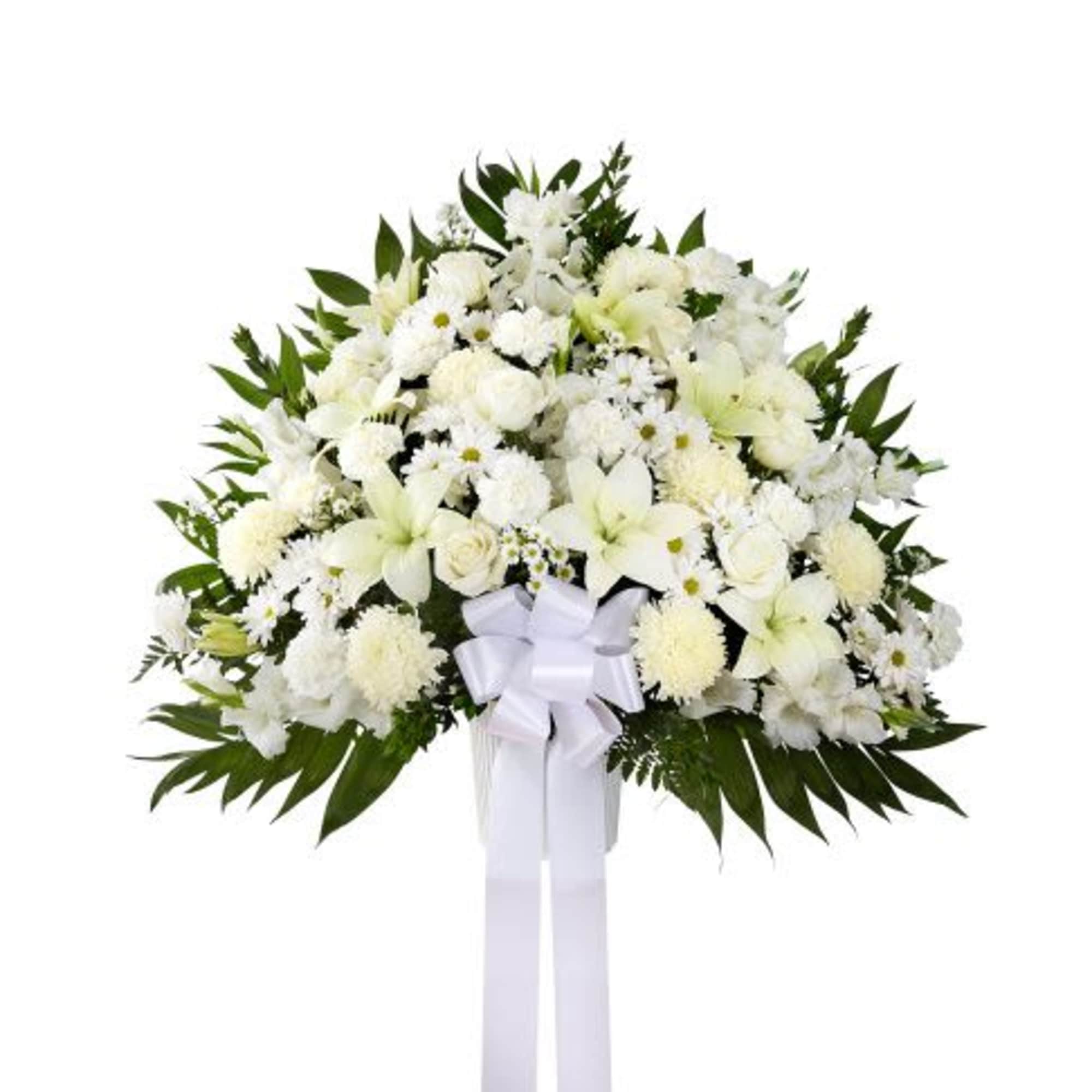 Tall white standing spray of lilies, roses, and mums with a large white bow on a stand