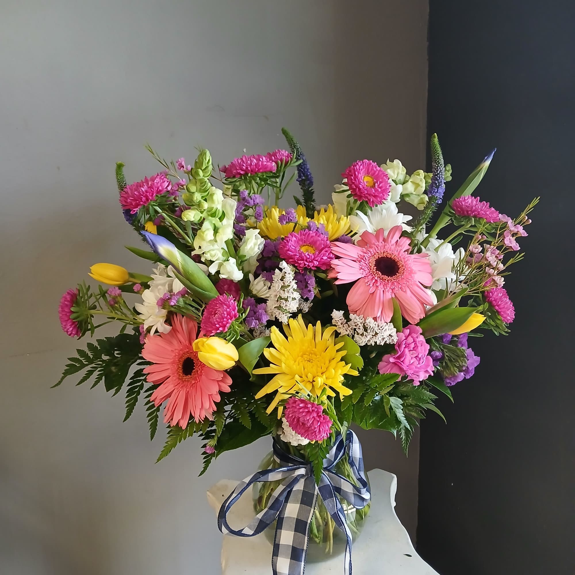 This beautiful flower arrangement of fresh mixed seasonal blooms is made by