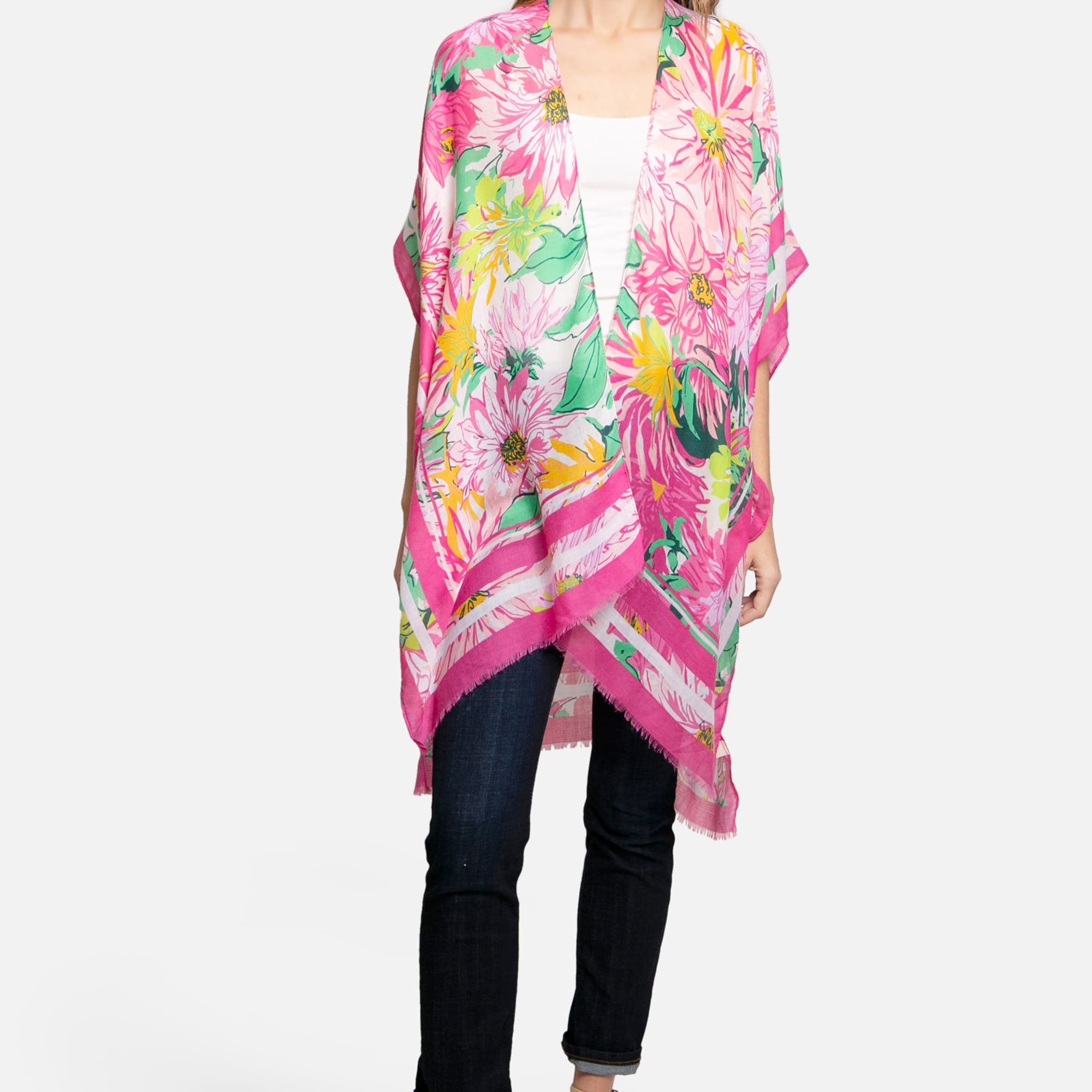 Woman wearing a bright pink floral kimono wrap over jeans and a white top