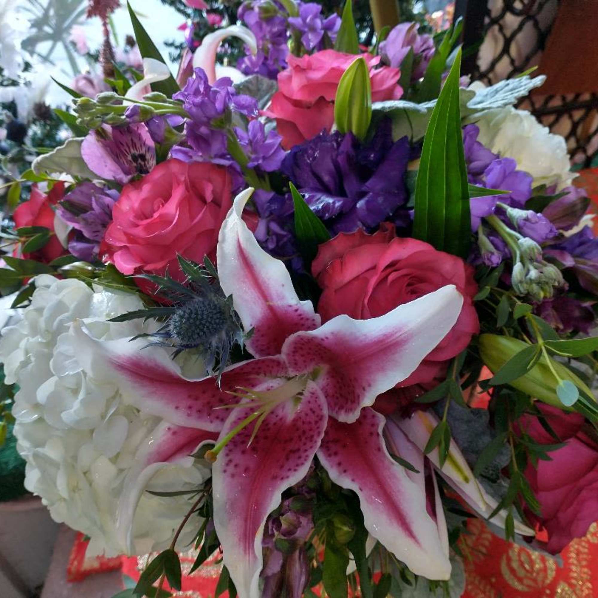 Bouquet of pink roses, white lilies, and purple flowers