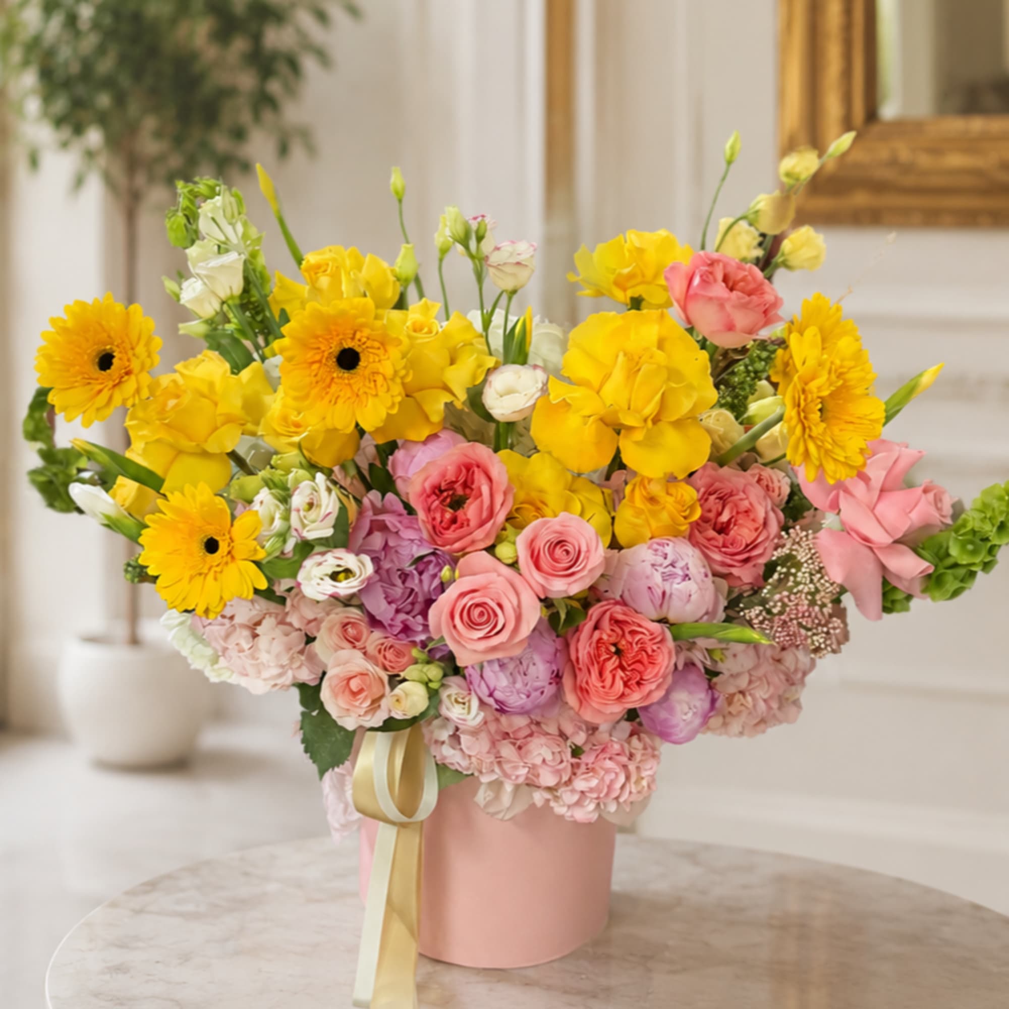 A burst of sunny yellow gerbera daisies and roses crowns this Wynwood