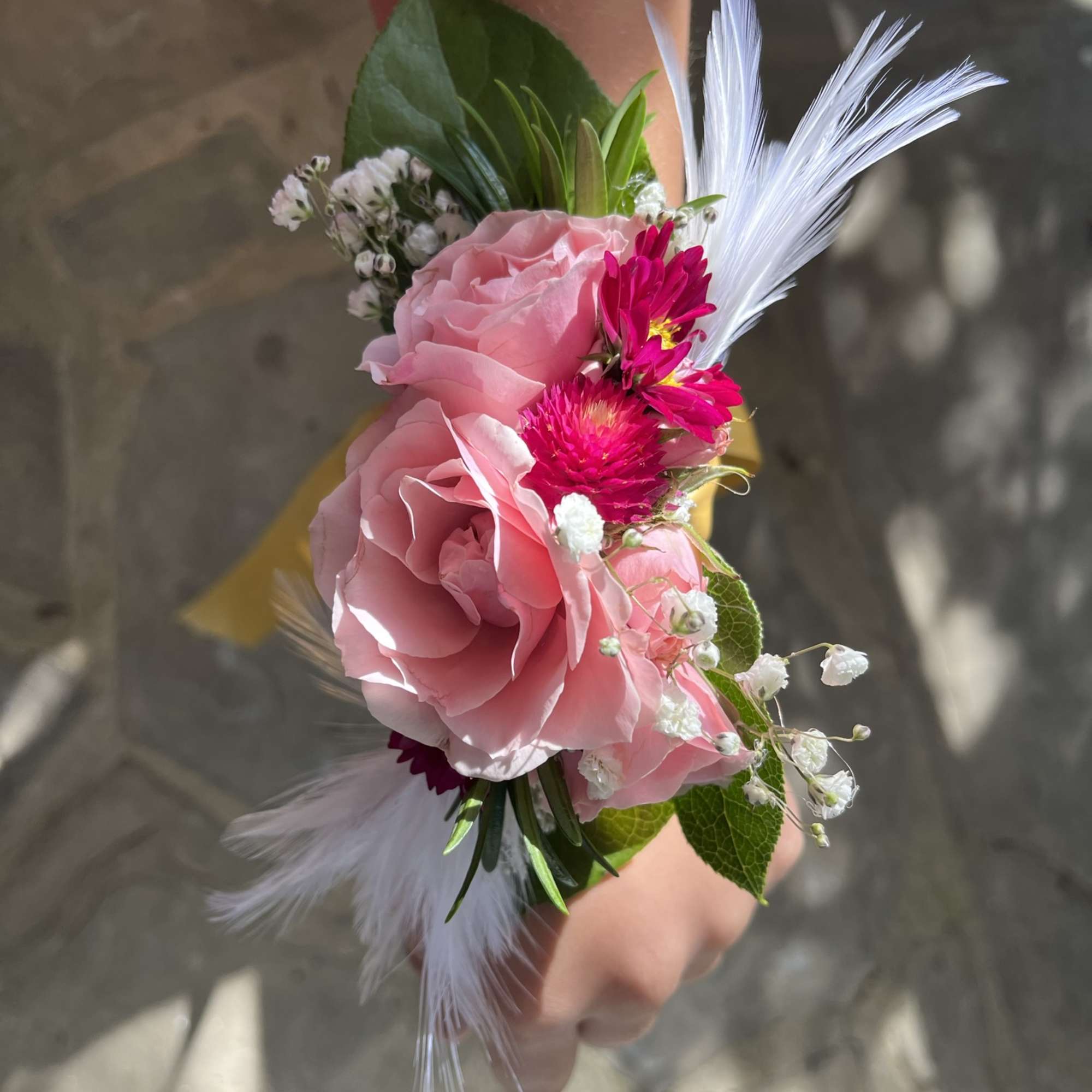 A small arrangement of beautiful flowers and greens secured to a snap