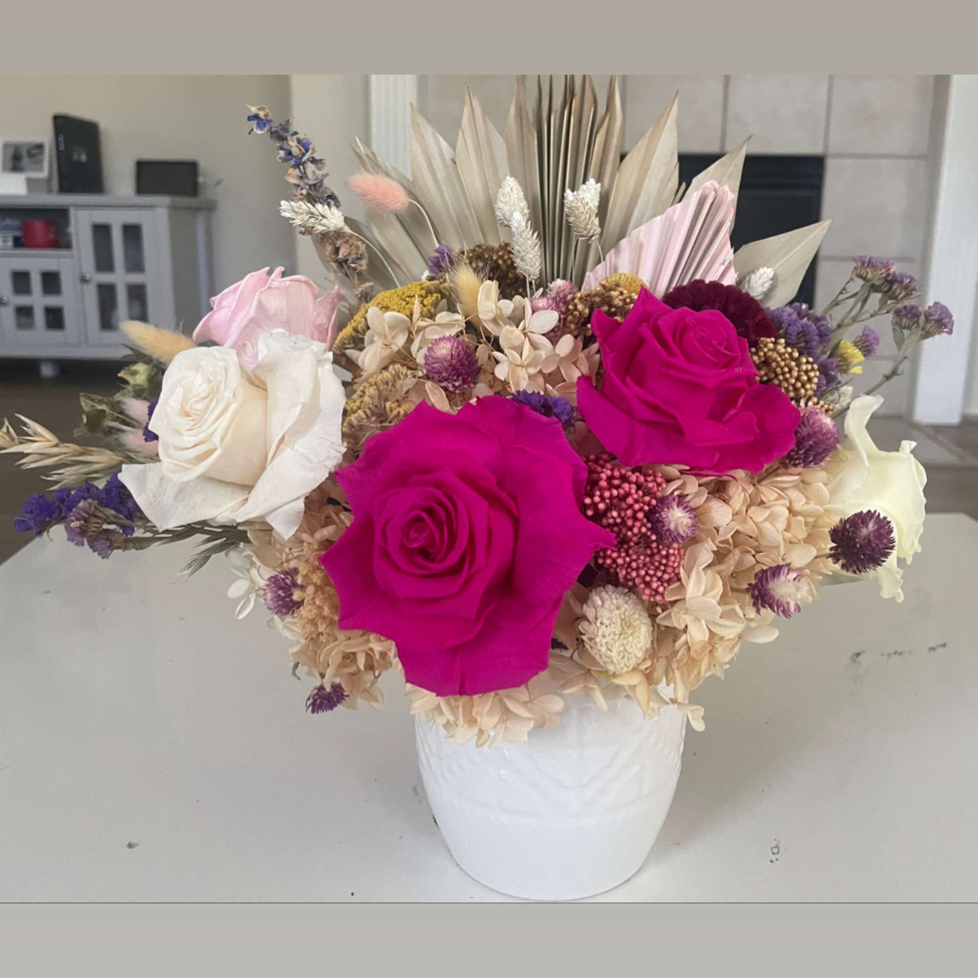 Bouquet of hot pink and white roses in a white vase