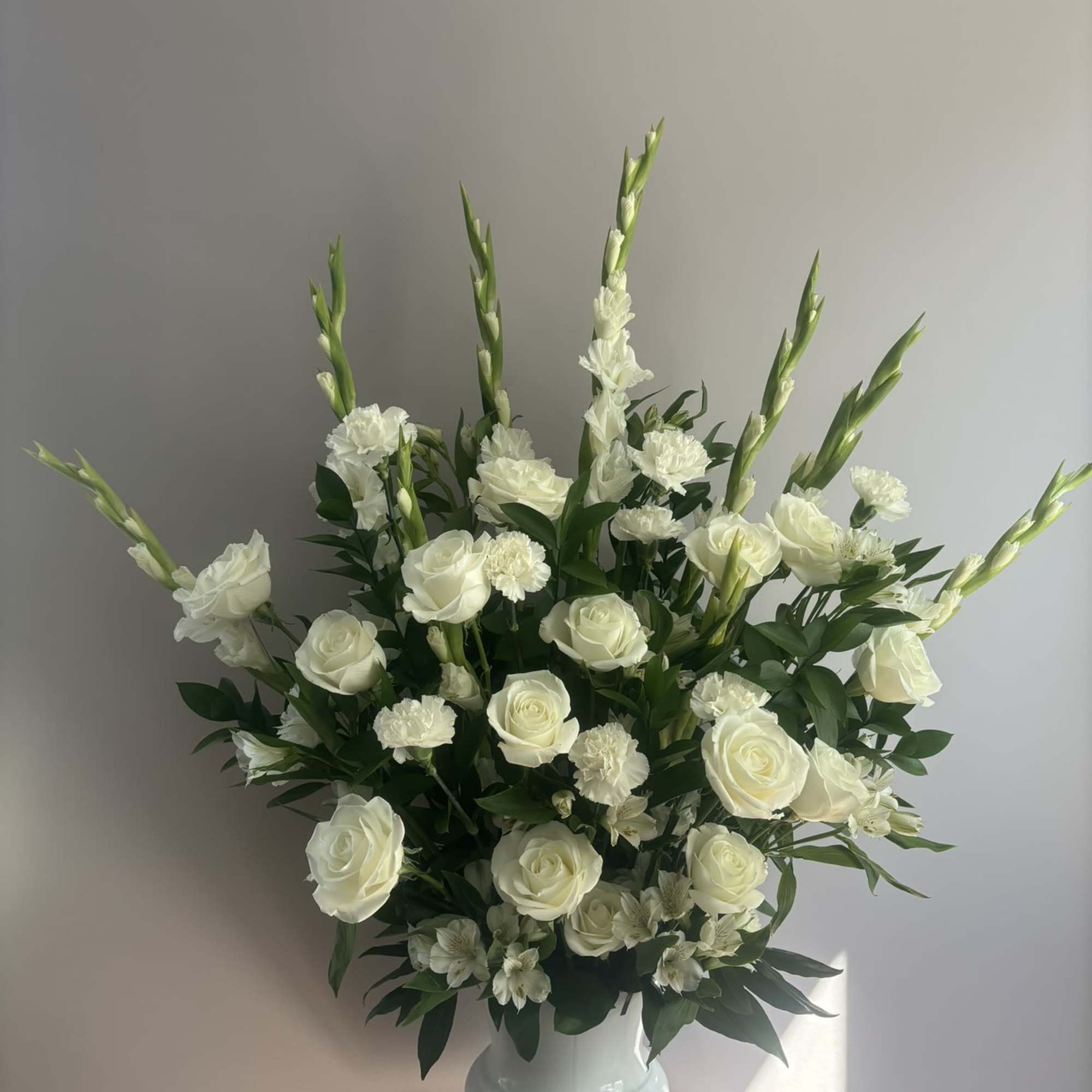 White roses and carnations in a white vase