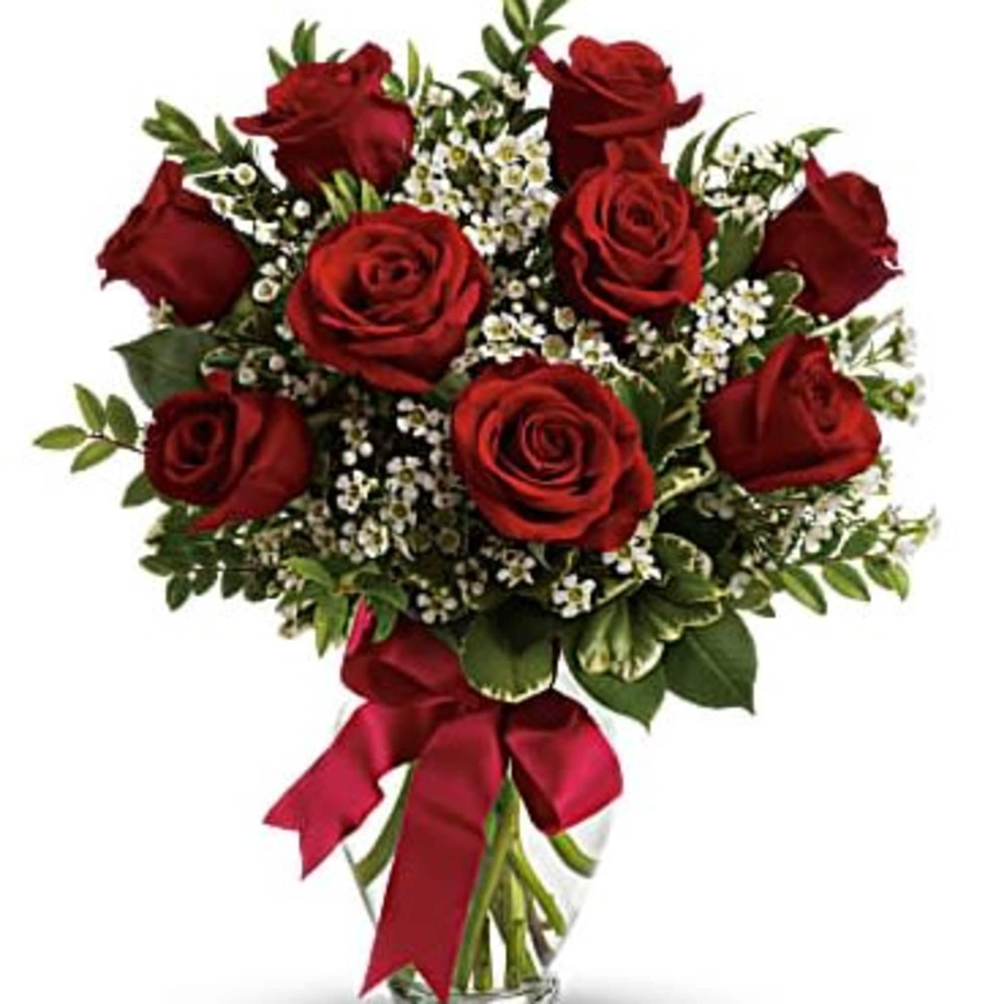 Bouquet of red roses with white filler flowers in a clear glass vase