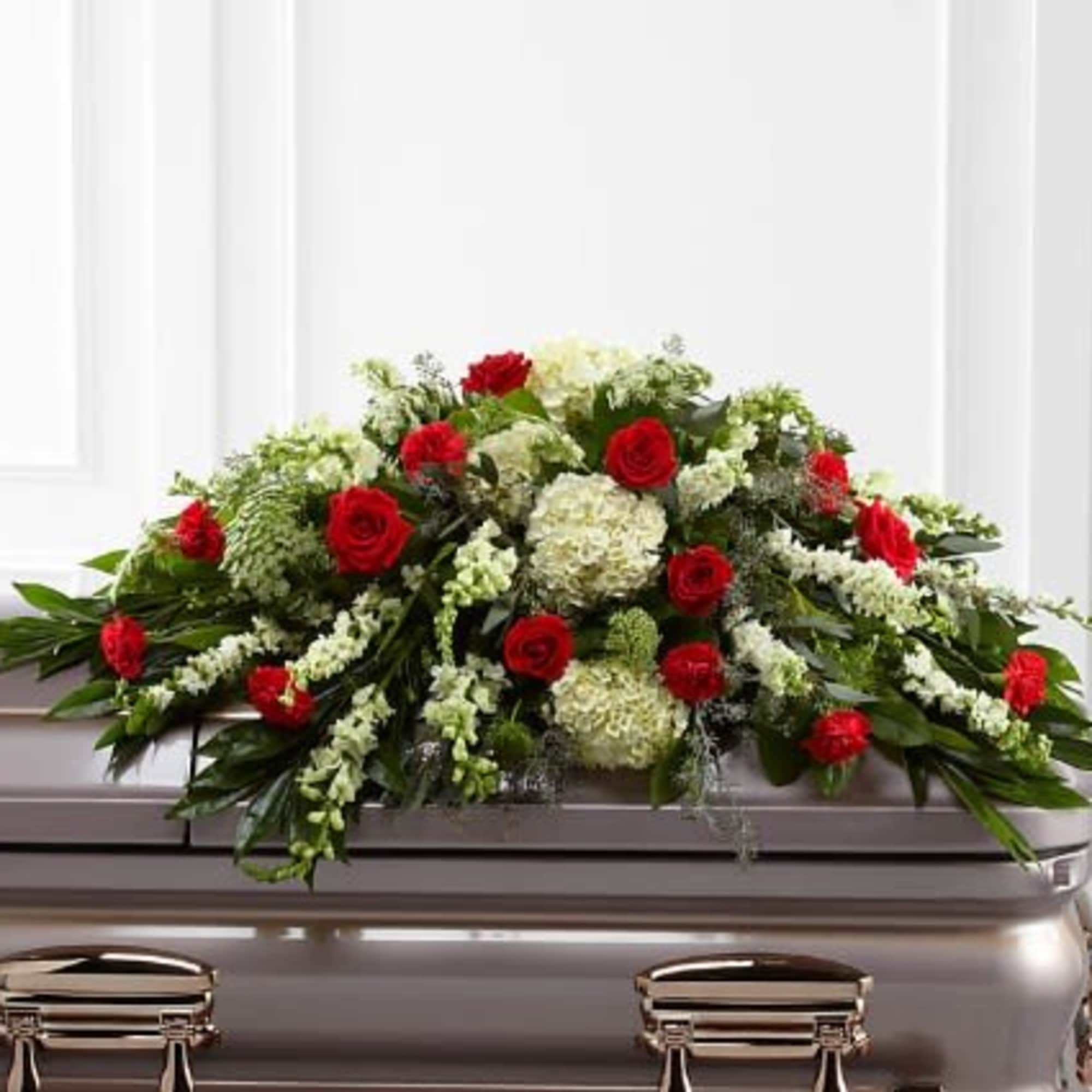 Red roses and white flowers arranged on a casket