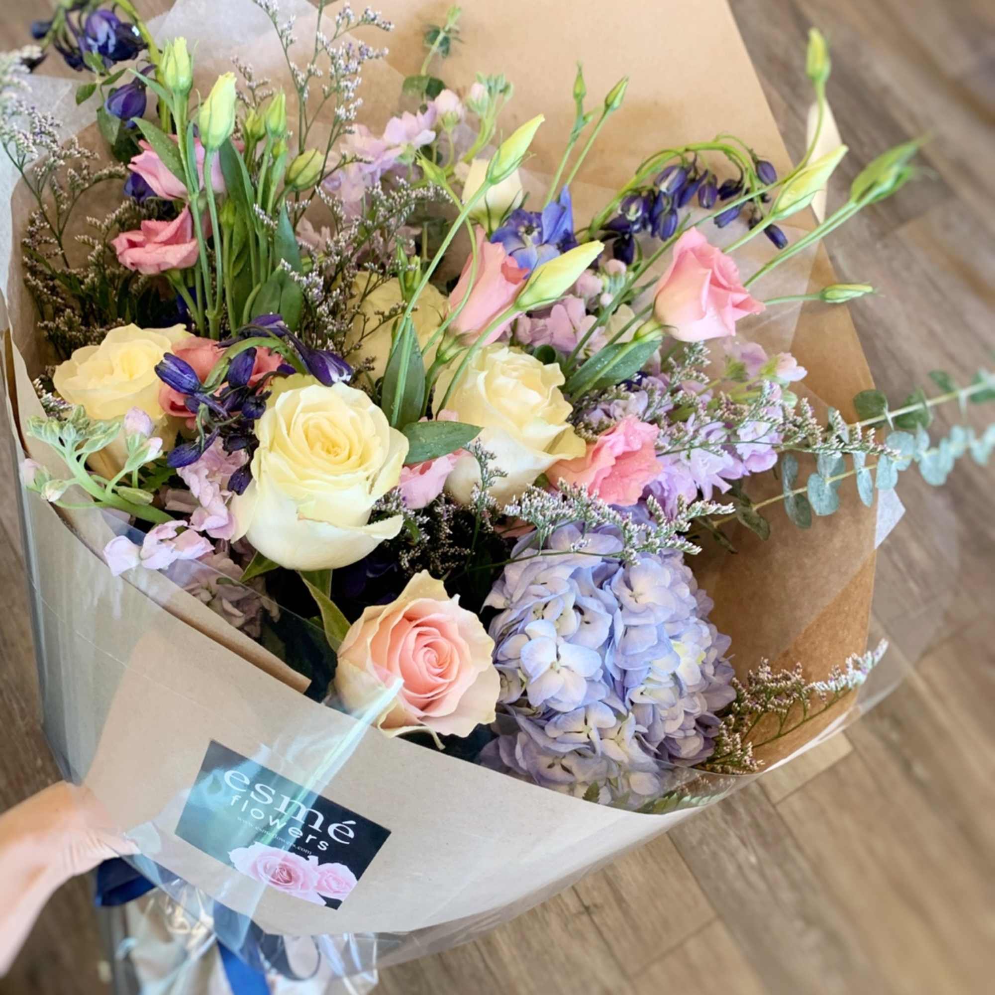 Hand-tied bouquet of pastel roses, lisianthus, and hydrangea