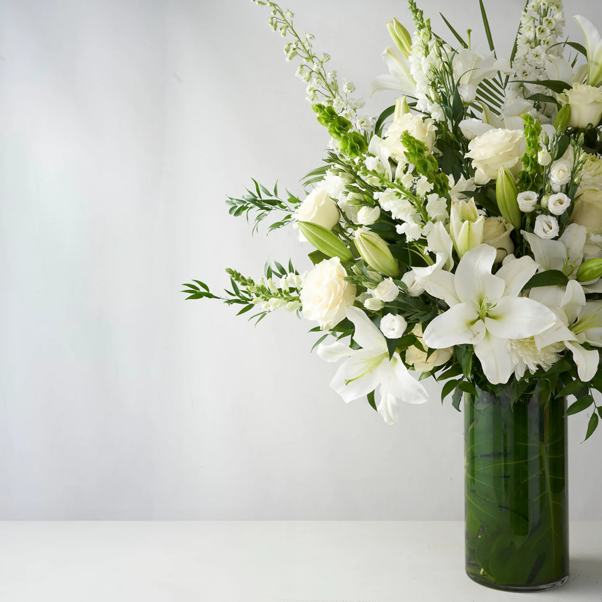 White floral arrangement in a tall glass vase