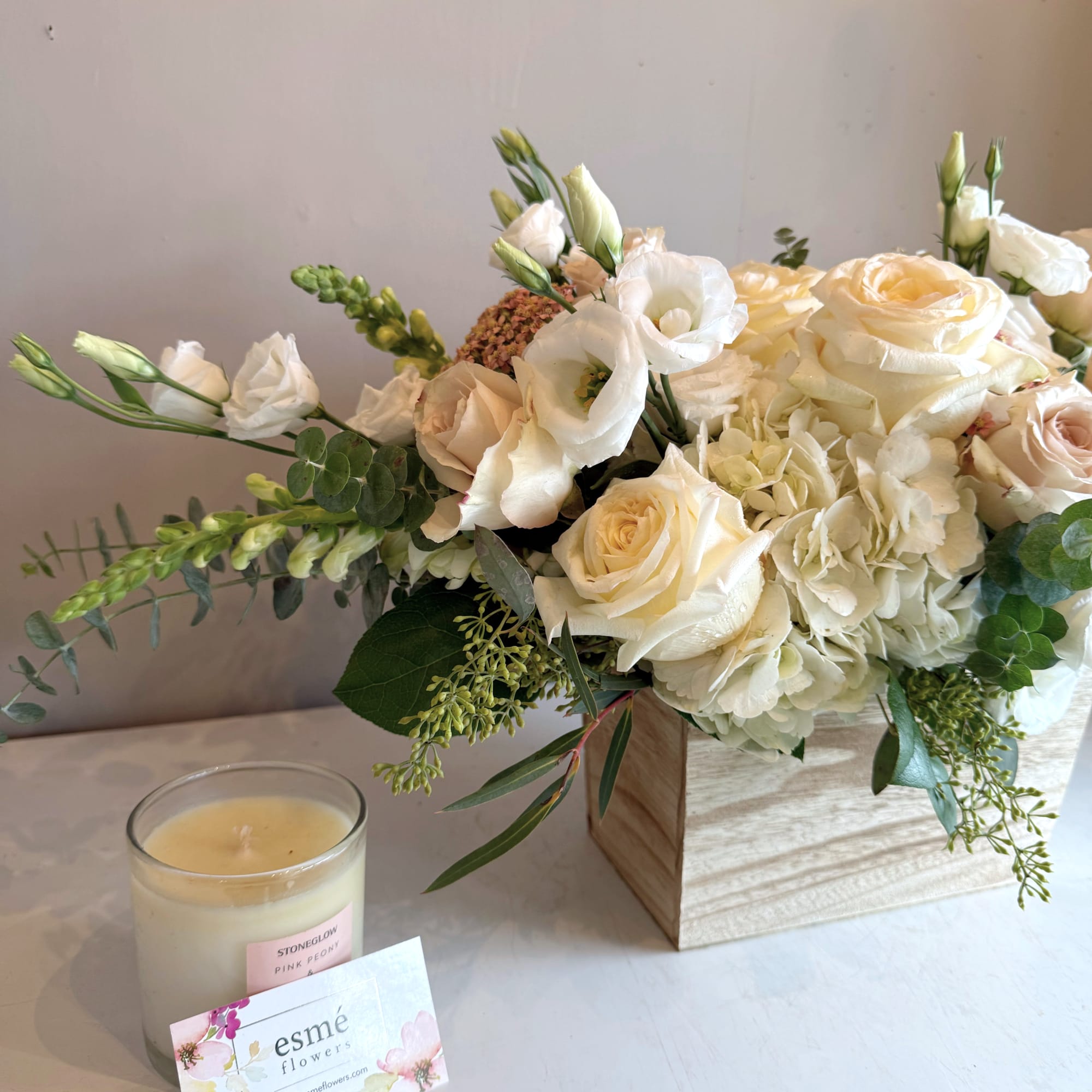 Cream and white bouquet with roses and lisianthus in a wooden box