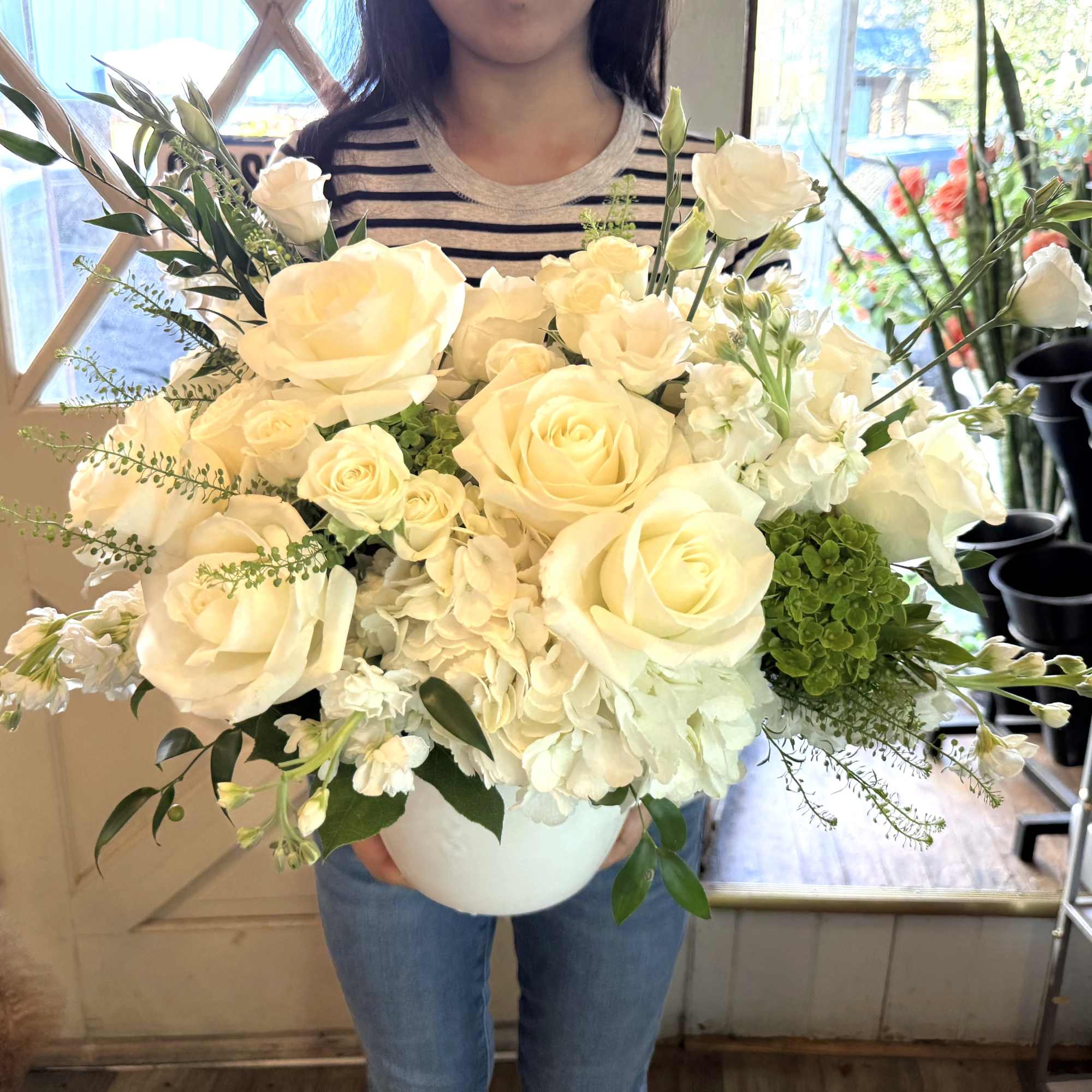 Large bouquet of white roses and hydrangea in a white vase