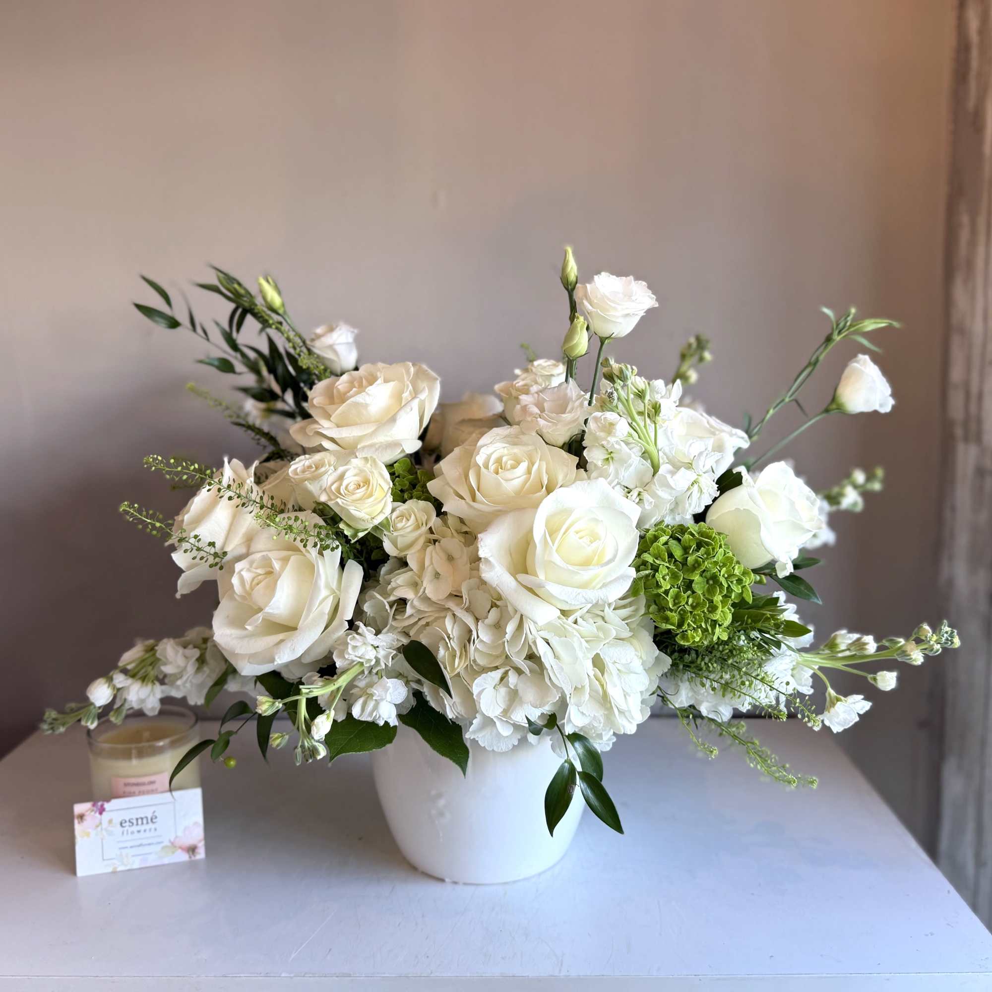 White rose and hydrangea arrangement in a white vase