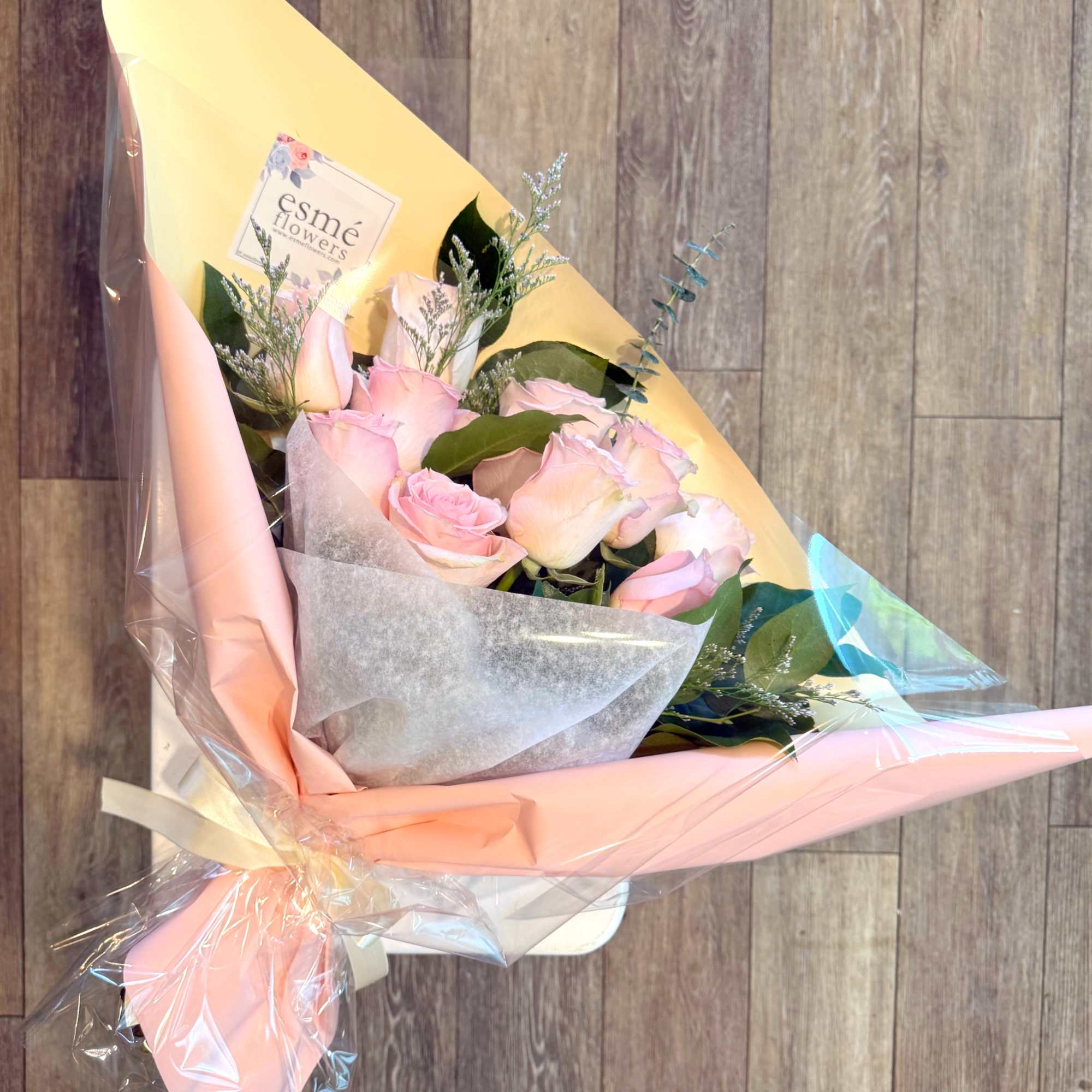 Bouquet of pale pink roses wrapped in pastel paper